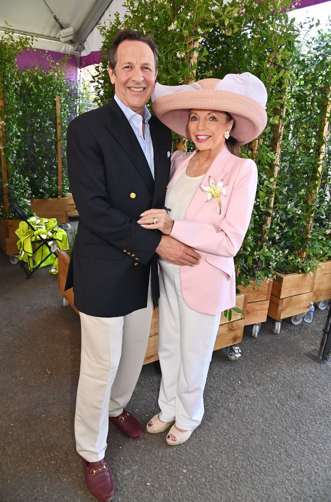 El 20 de mayo de 2024, Joan Collins y Percy Gibson asistieron al RHS Chelsea Flower Show en el jardín "Money Doesn't Grow On Trees" de Killik & Co, donde mostraron su duradera relación en un entorno vibrante | Fuente: Getty Images