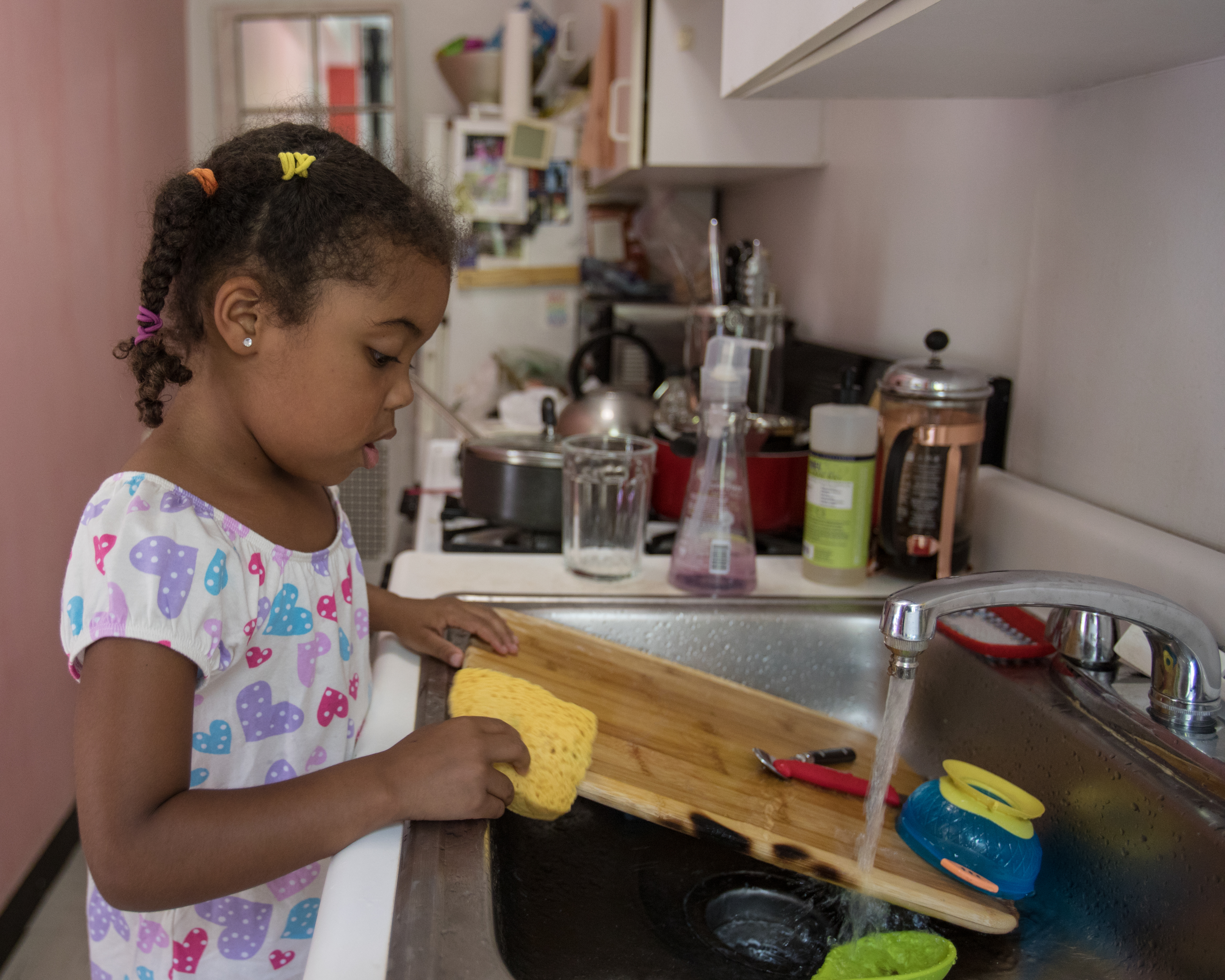 Niña lava los platos en una cocina | Foto: Getty Images