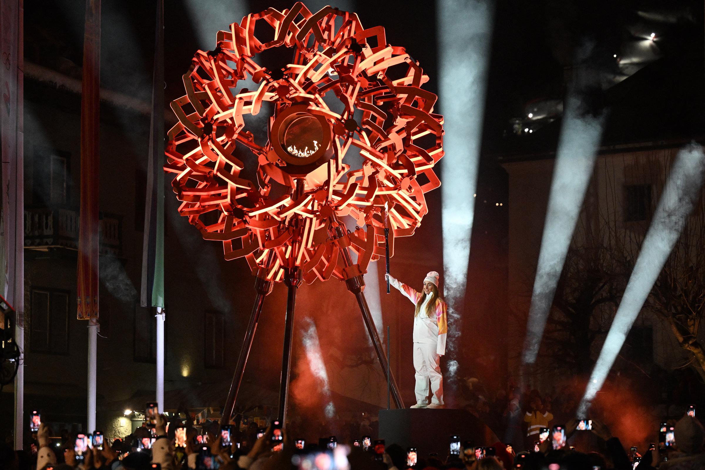 La italiana Sofia Goggia, portadora de la antorcha, enciende el pebetero durante la ceremonia inaugural de los Juegos Olímpicos de Invierno Milano Cortina 2026 en Cortina d'Ampezzo, norte de Italia, el 6 de febrero de 2026. | Fuente: Getty Images