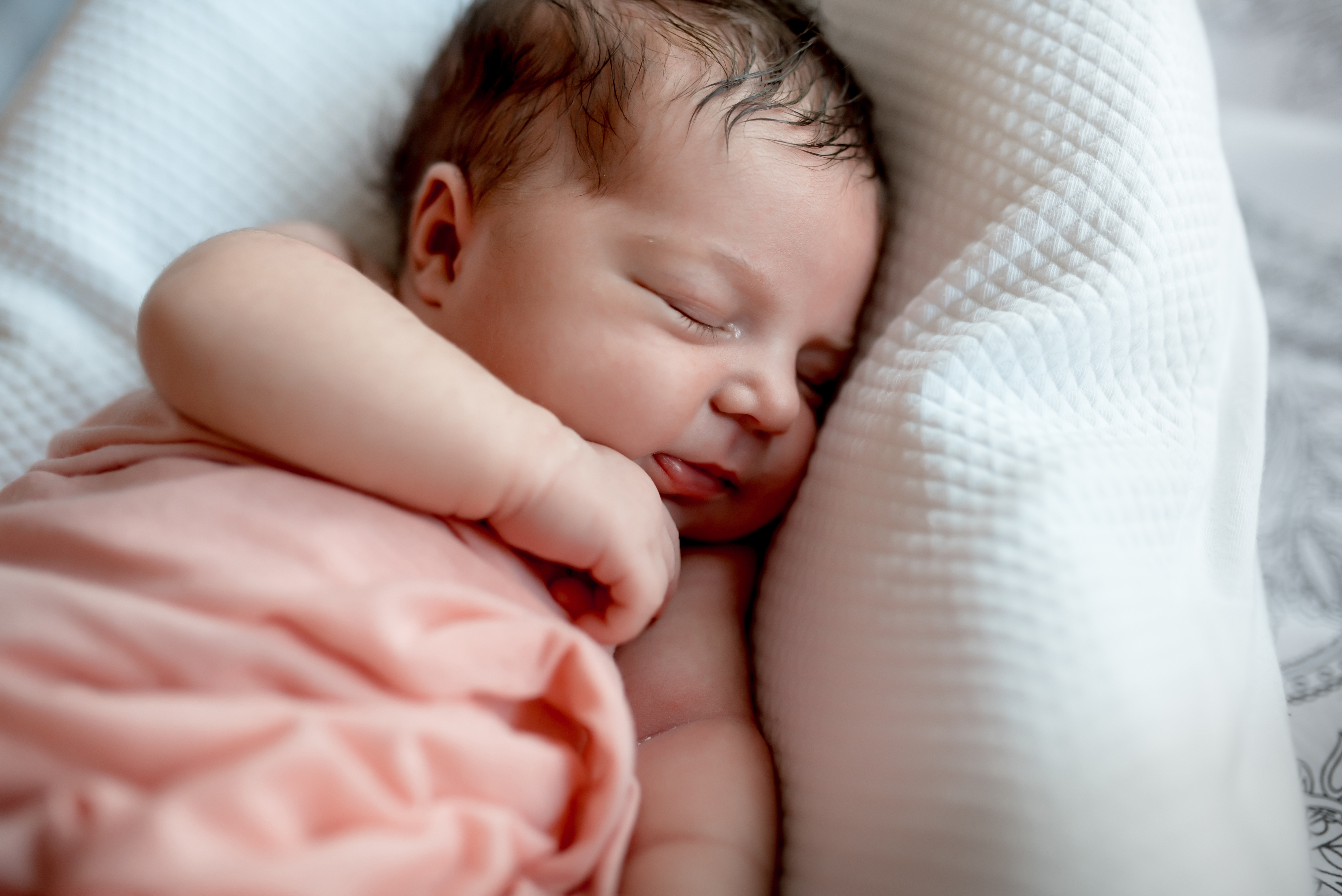 Recién nacido durmiendo en la cama | Fuente: Shutterstock.com
