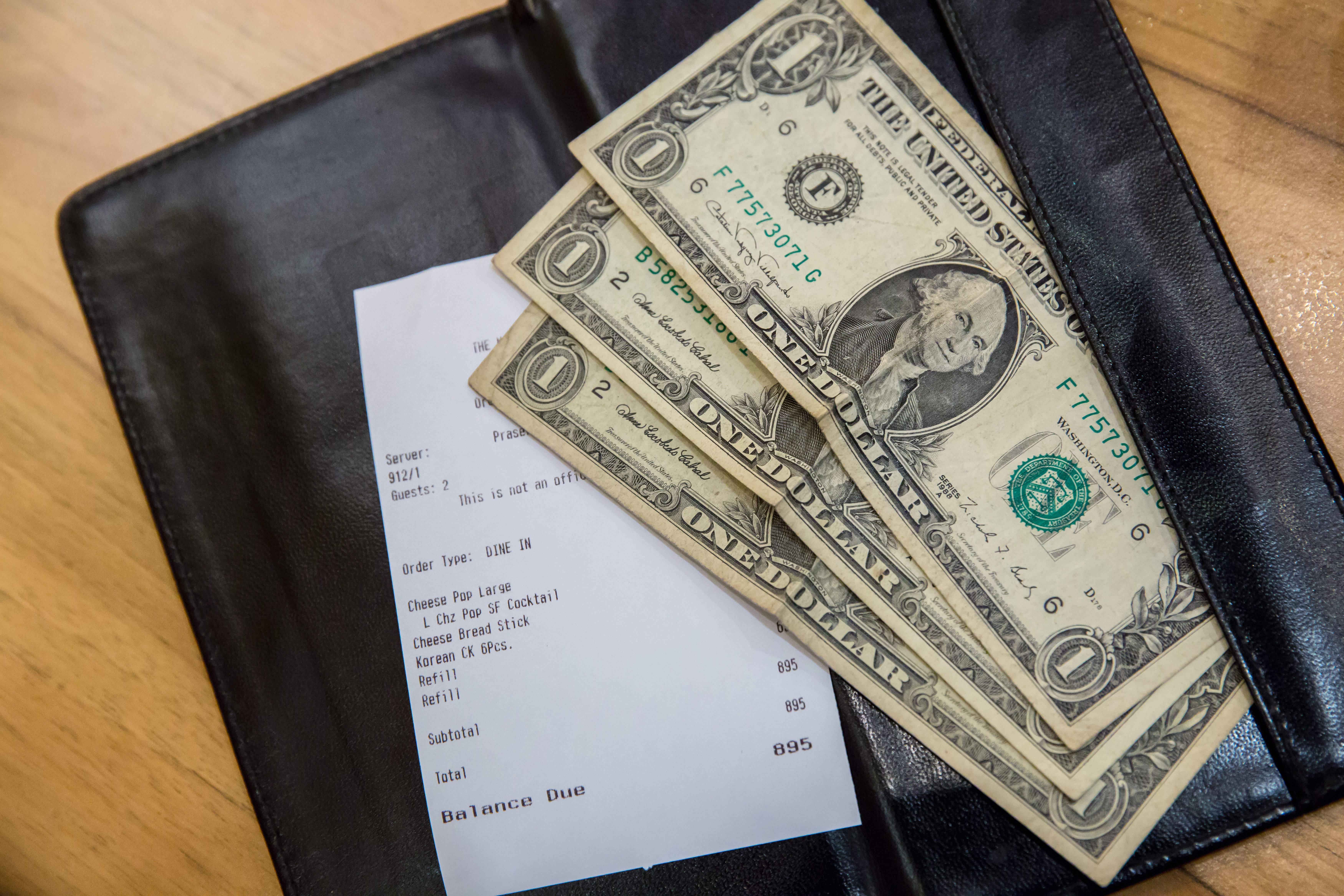 La cuenta de un restaurante y unos cuantos dólares. | Foto: Shutterstock
