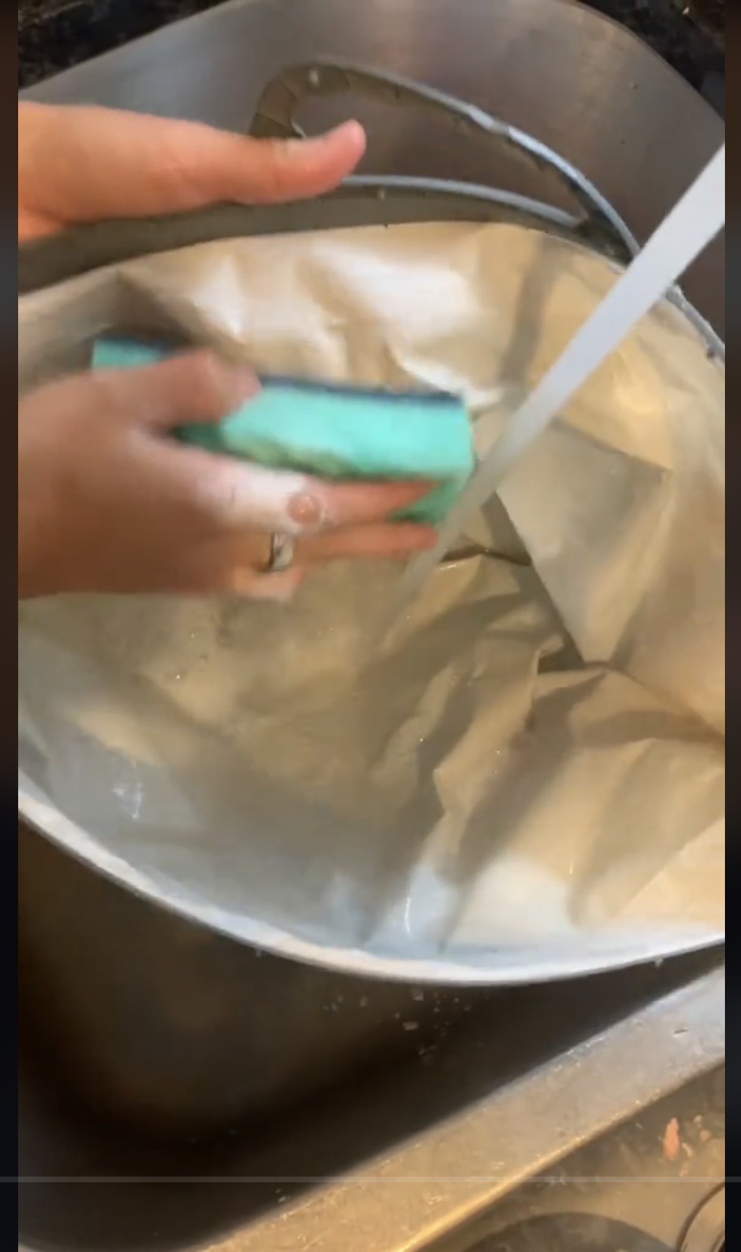 Una persona lava una bolsa de la compra reutilizable con agua jabonosa, como se ve en un vídeo del 22 de septiembre de 2023 | Fuente: TikTok/@consumerreports