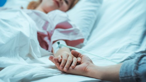 Mujer hospitalizada le da la mano a un familiar. | Foto: Shutterstock