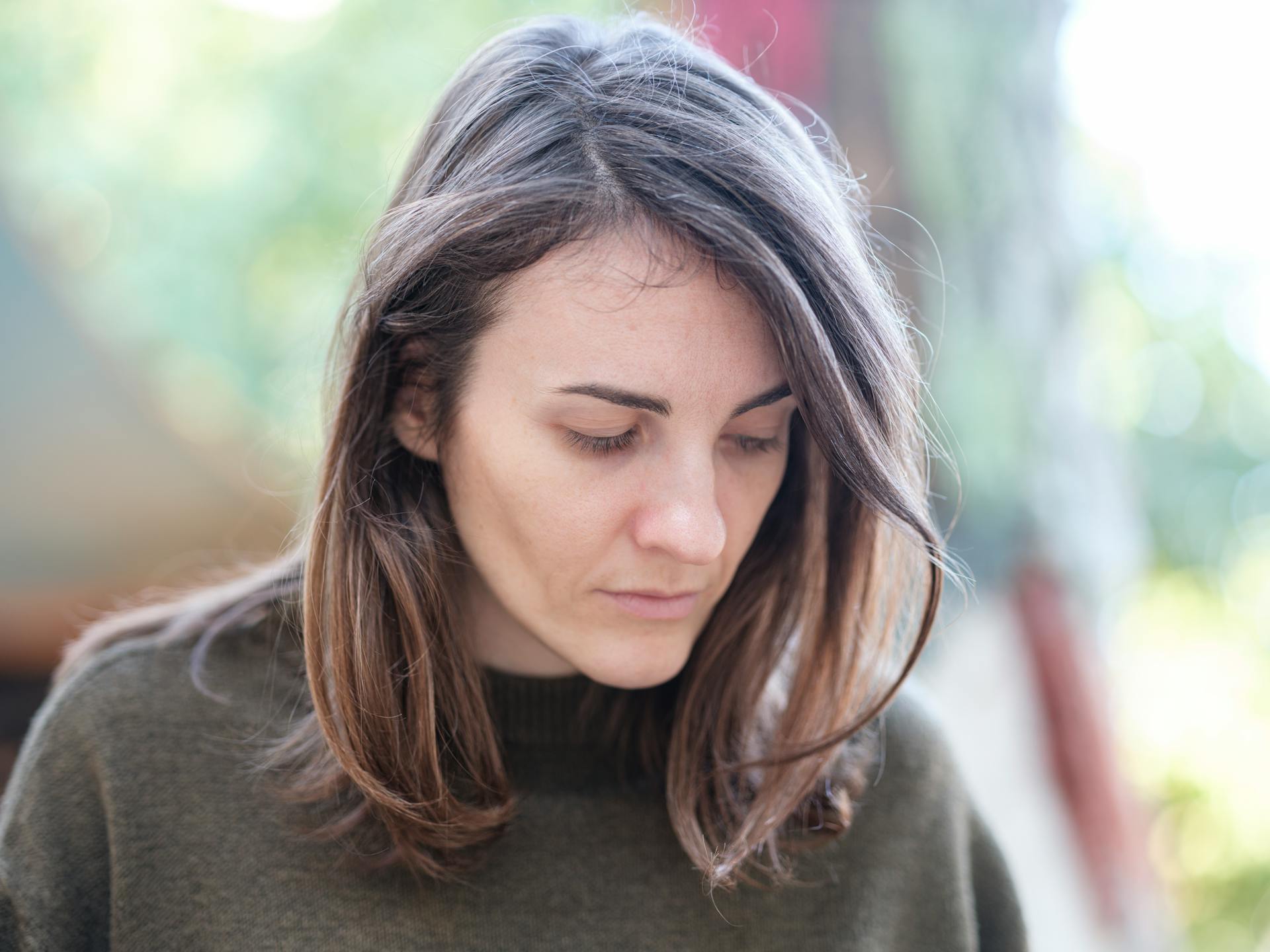 Una mujer mirando hacia abajo | Fuente: Pexels