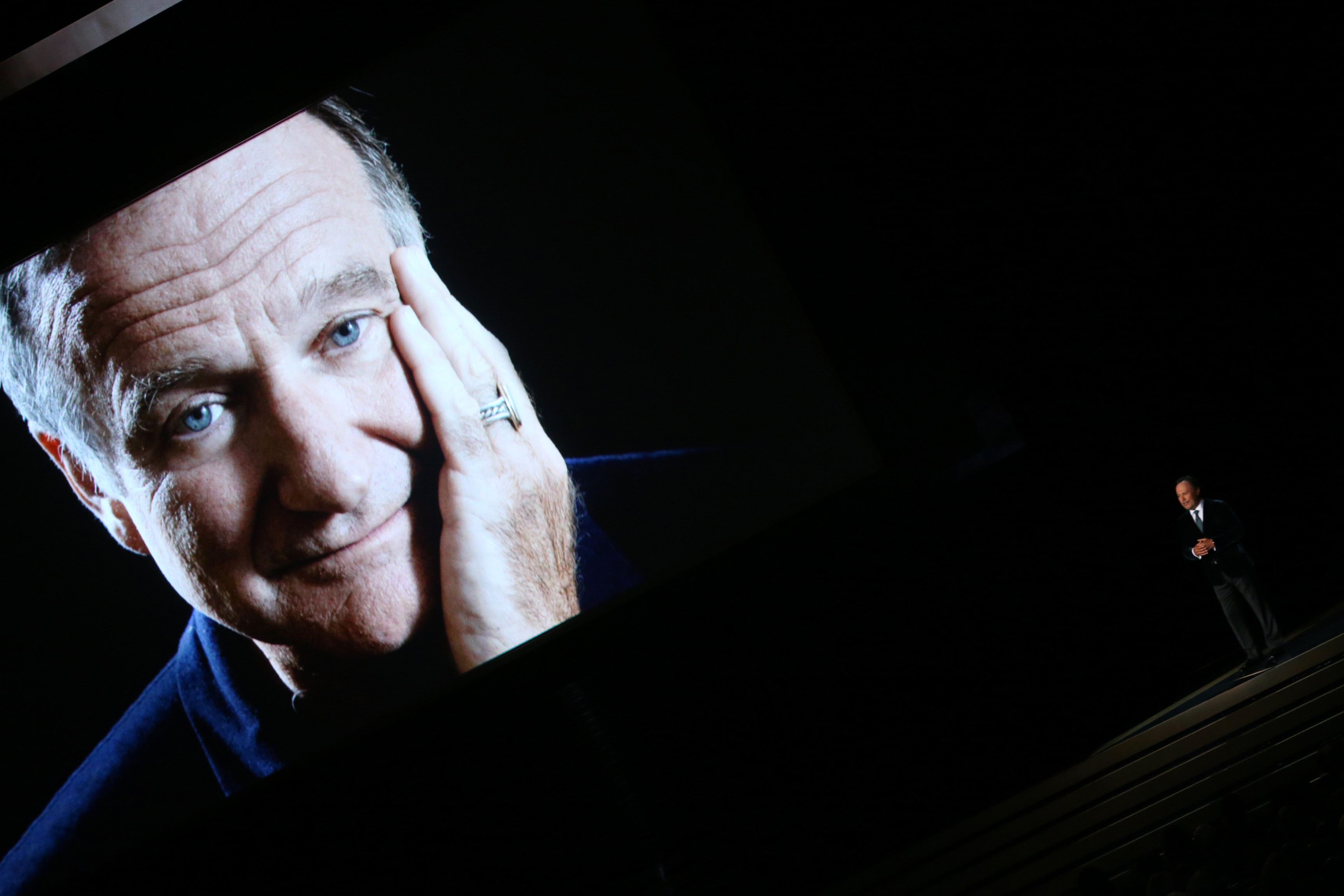 Una imagen del fallecido Robin Williams aparece mientras el cómico Billy Crystal habla durante la 66 edición de los Premios Emmy Primetime el 25 de agosto de 2014 | Fuente: Getty Images