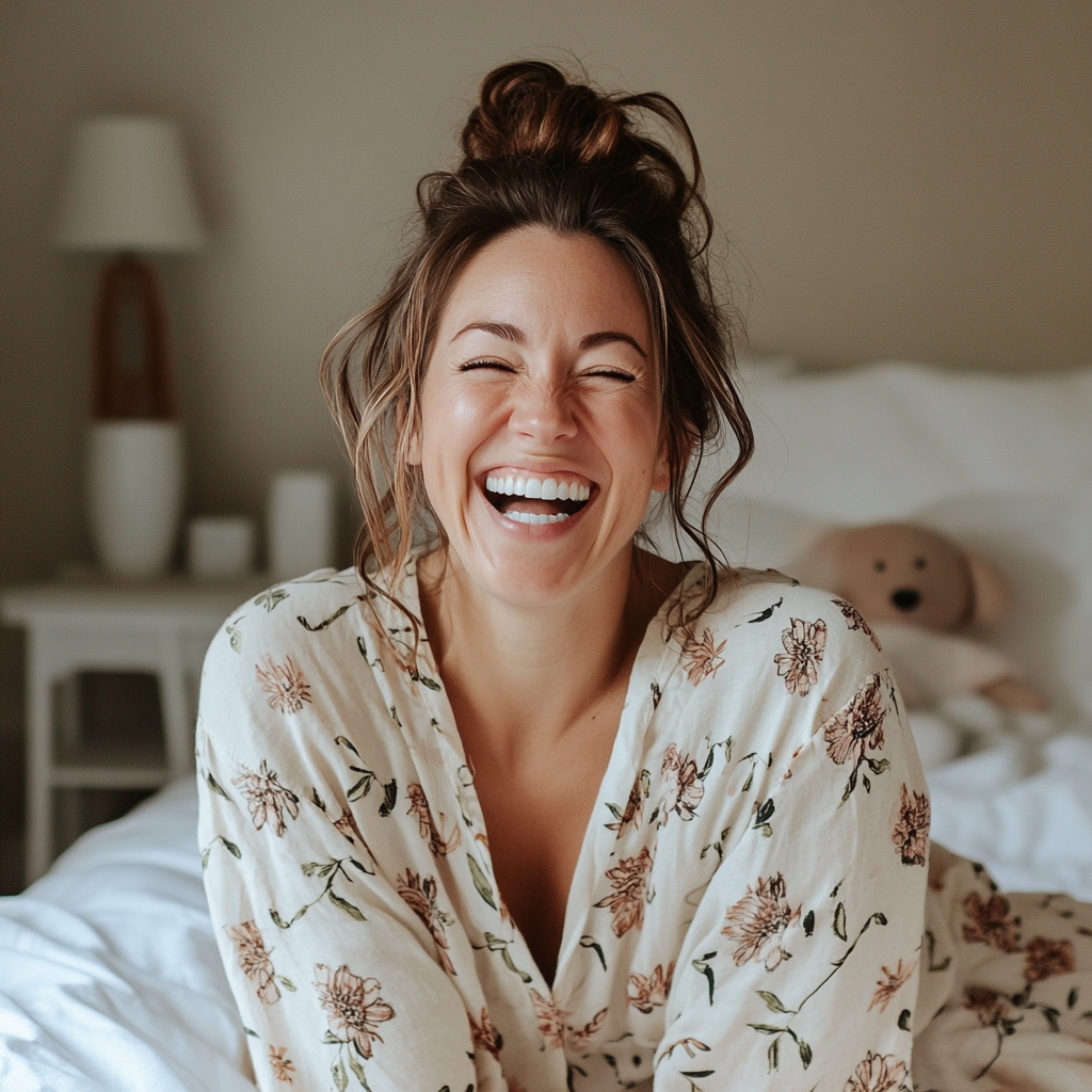 Una mujer sentada en su cama y riendo | Fuente: Midjourney