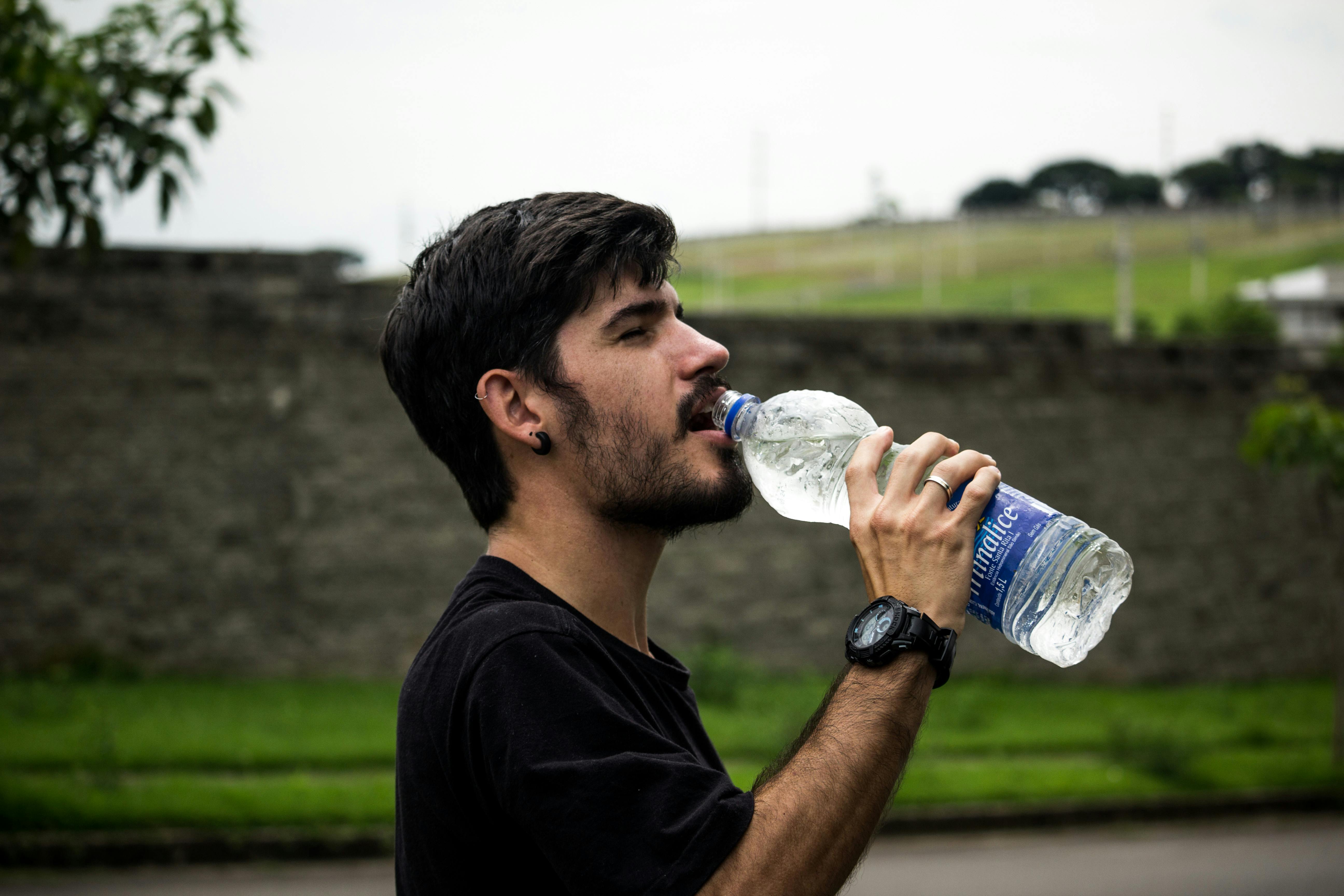 Hombre bebe agua | Fuente: Pexels