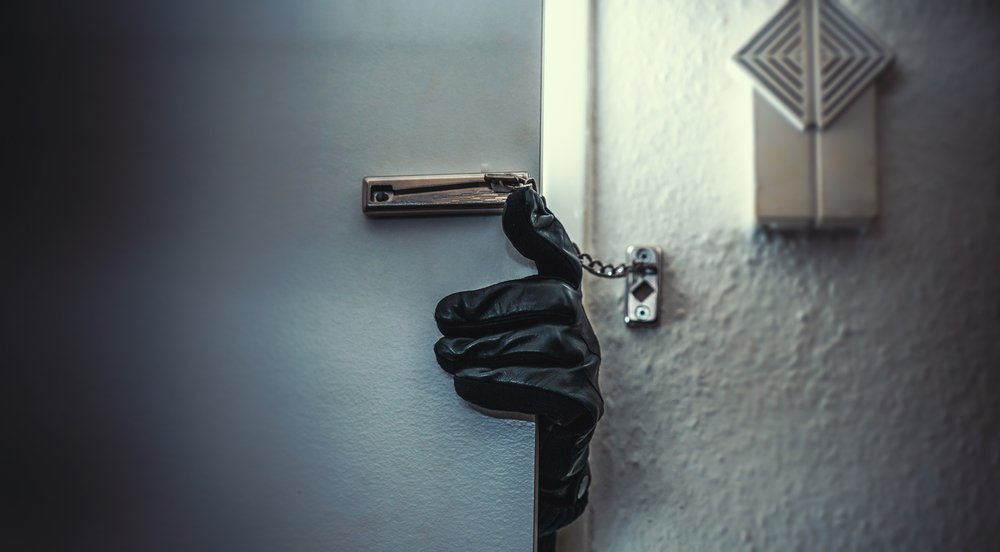 Ladrón enmascarado entrando en el hogar de una víctima. Fuente: Shutterstock