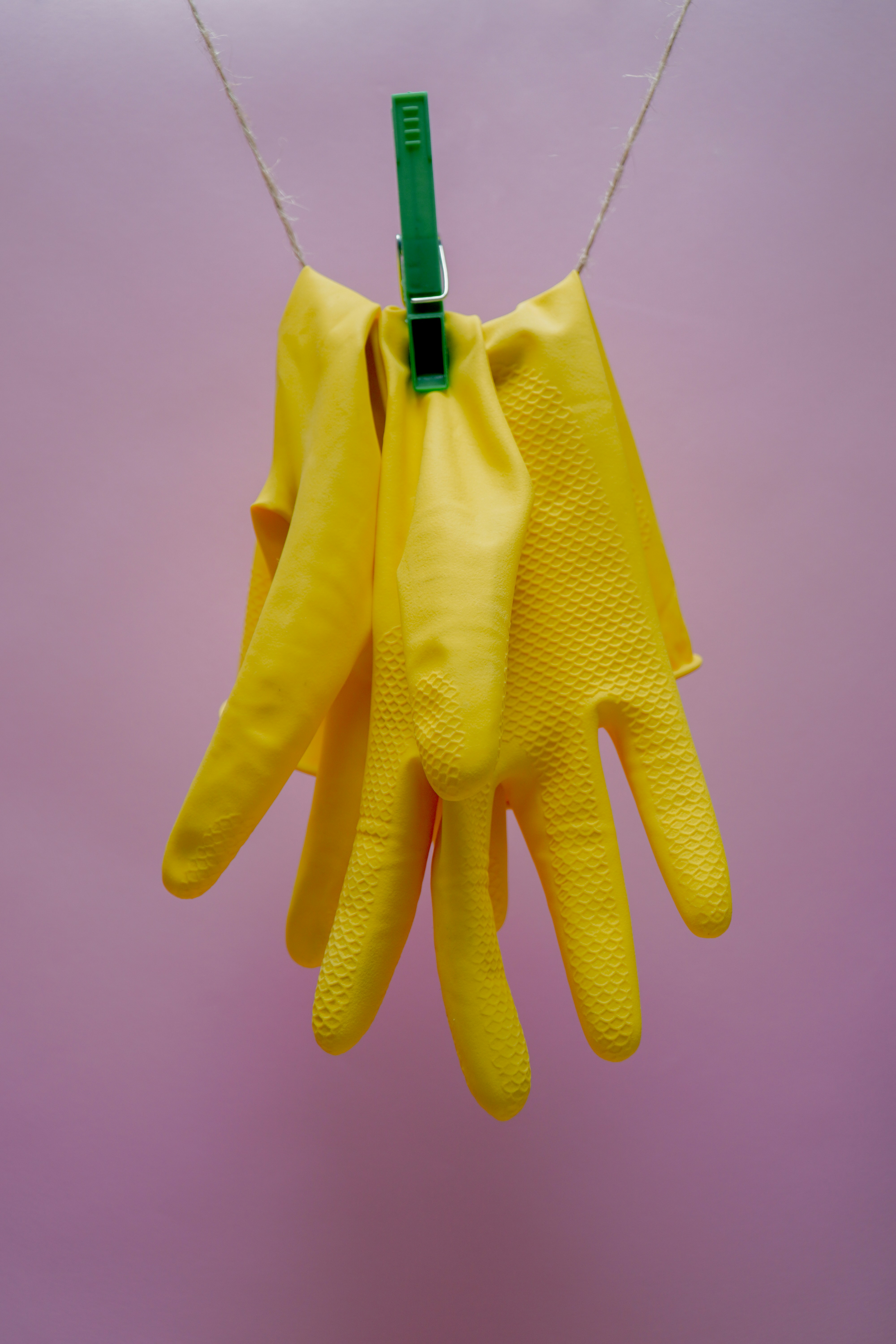 Guantes amarillos colgados con una pinza | Fuente: Unsplash