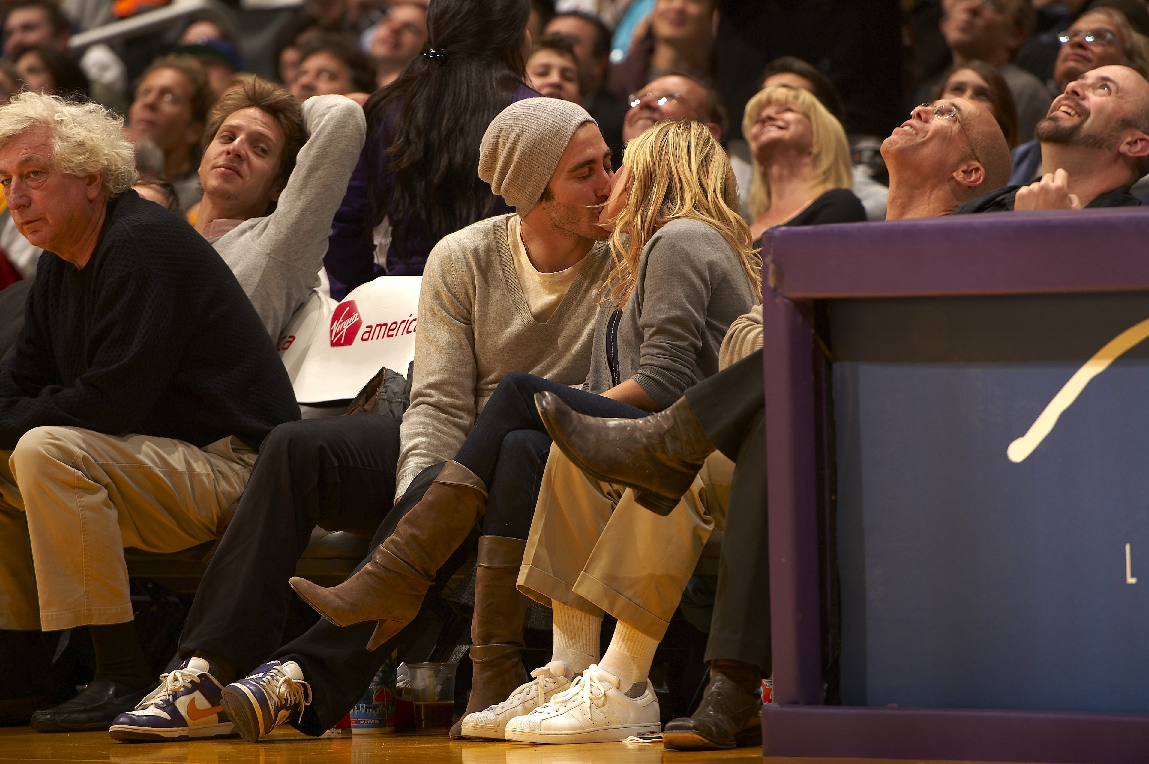 Gyllenhaal y Witherspoon comparten un beso en la cancha durante el partido entre Los Angeles Lakers y Portland Trail Blazers, el 4 de enero de 2009, en Los Angeles, California. La pareja parece completamente enamorada, aparentemente ajena a la multitud que les rodea.