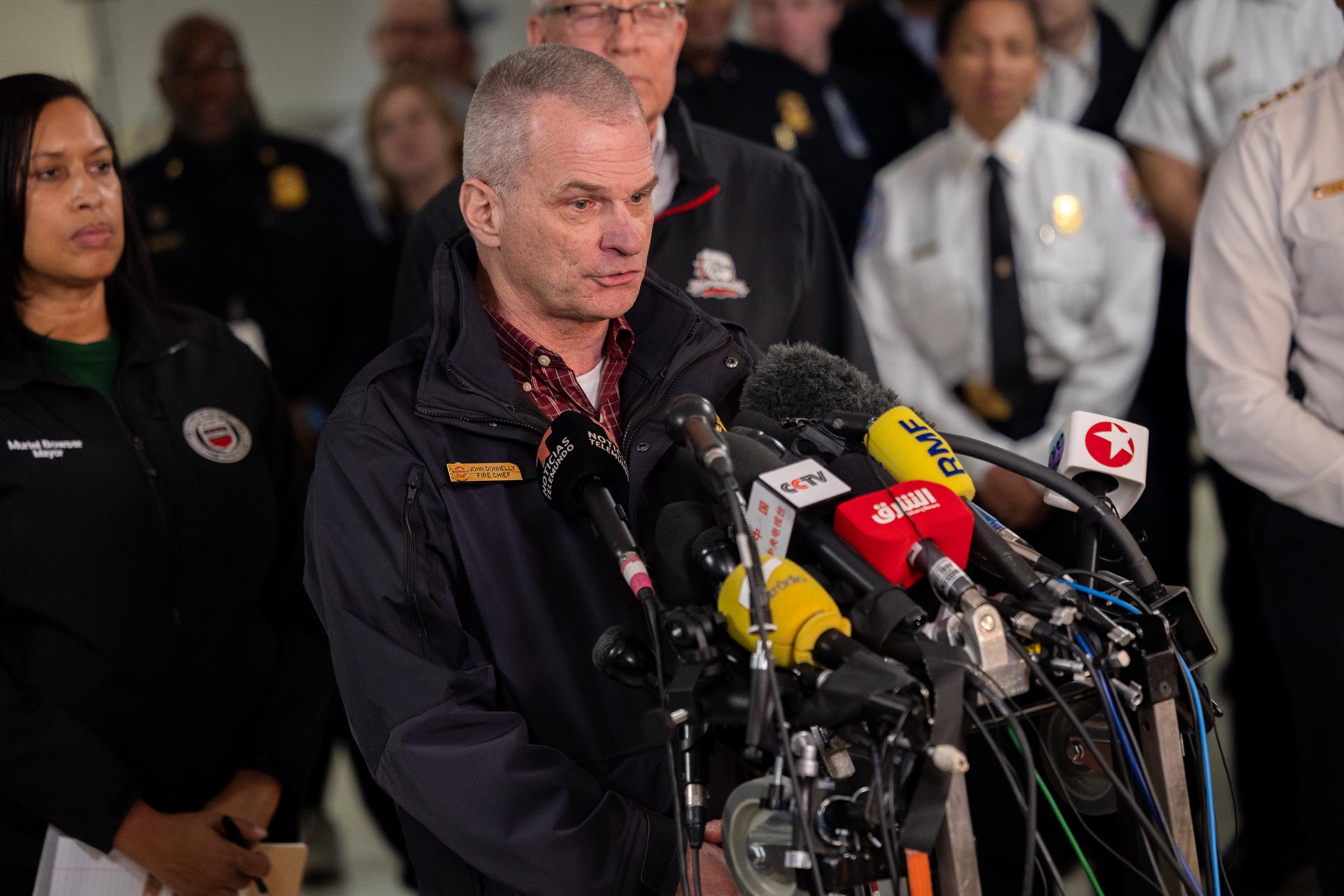 El jefe de bomberos y servicios médicos de urgencia de DC, John Donnelly, habla en rueda de prensa con otros funcionarios del gobierno sobre las labores de rescate tras la colisión entre un avión de American Airlines y un helicóptero del ejército en Washington, D.C., el 30 de enero de 2025. | Fuente: Getty Images