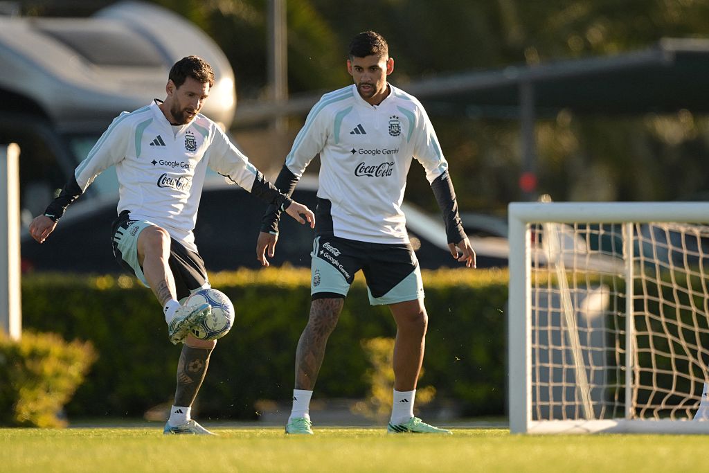Lionel Messi (izq.) pasa el balón junto a su compañero, el defensa Cristian Romero, durante un entrenamiento en el predio de la Asociación del Fútbol Argentino (AFA) en Ezeiza, provincia de Buenos Aires, el 5 de octubre de 2026, previo al partido amistoso contra Benín. | Fuente: Getty Images