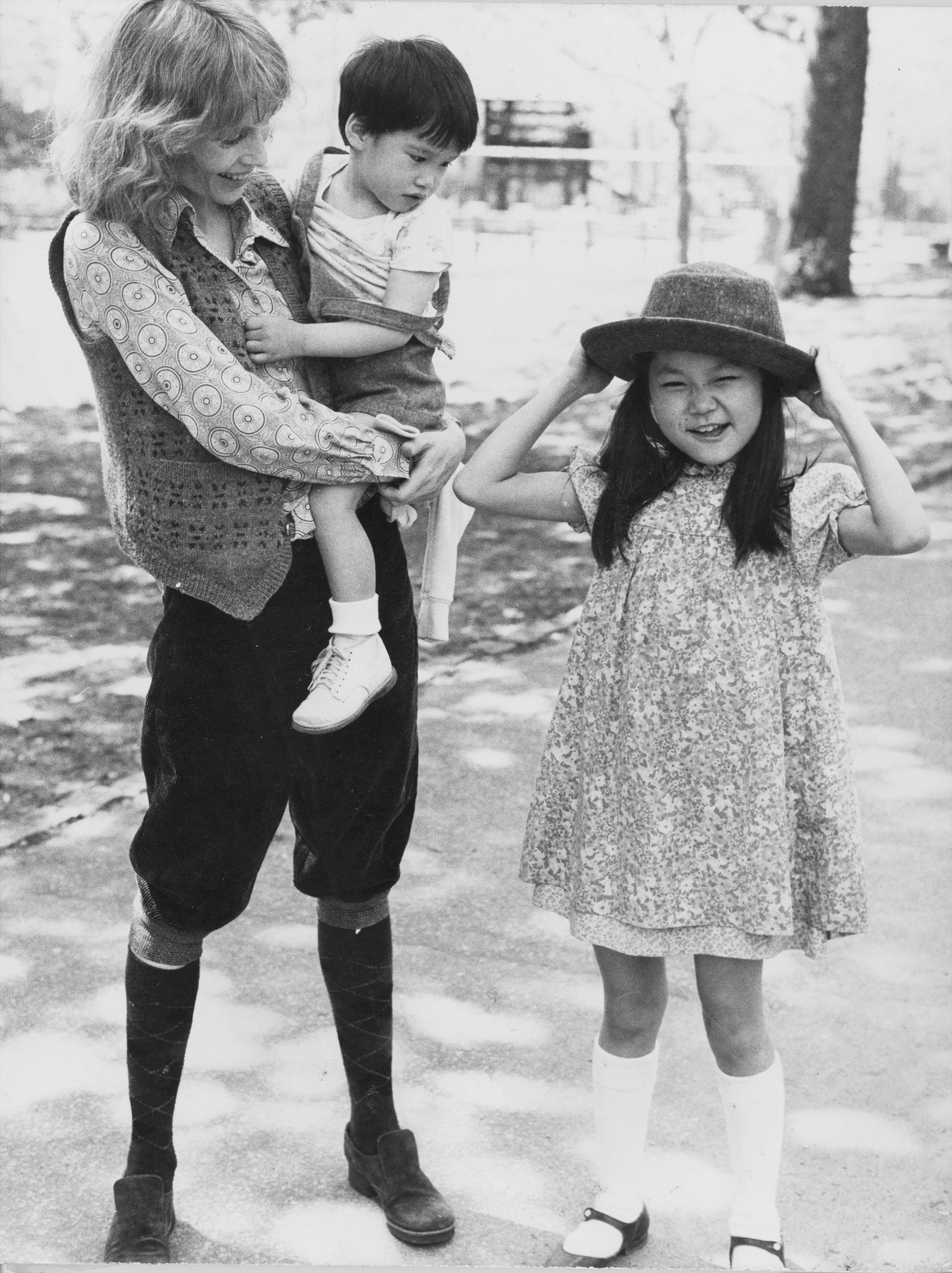 Mia Farrow sostiene a Misha mientras Soon Yi Previn se prueba el sombrero de mamá en Central Park, el 5 de mayo de 1980. | Fuente: Getty Images