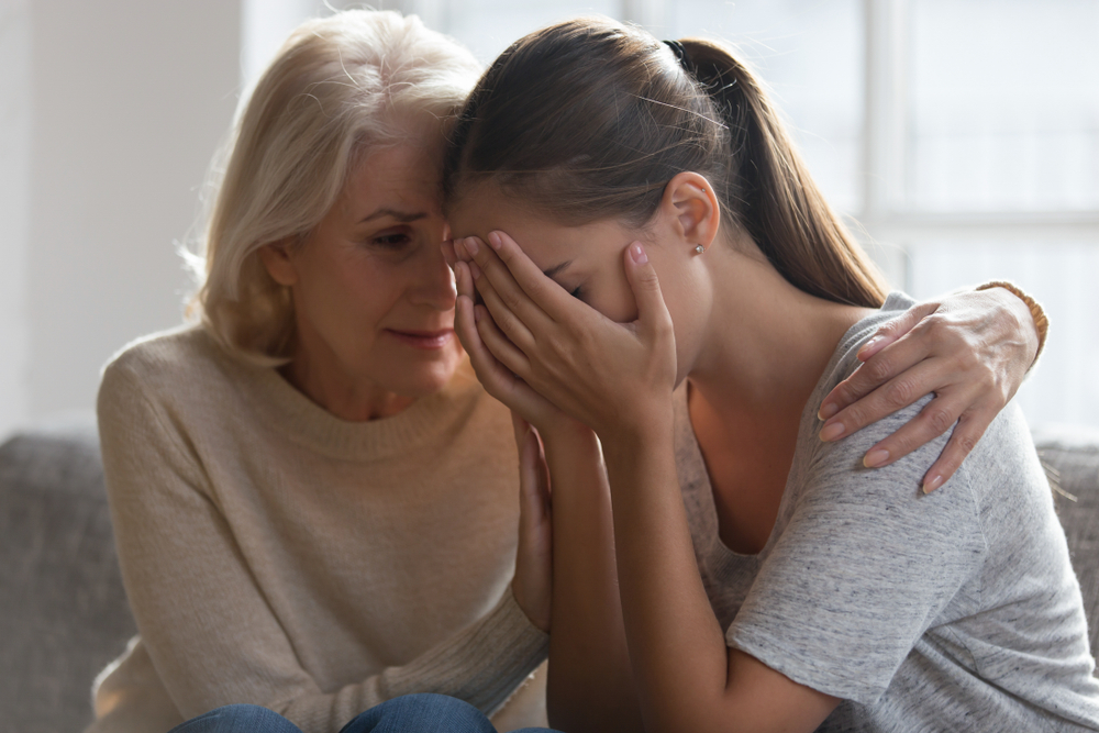 Una madre mayor y preocupada consuela a una hija adulta. | Foto: Shutterstock