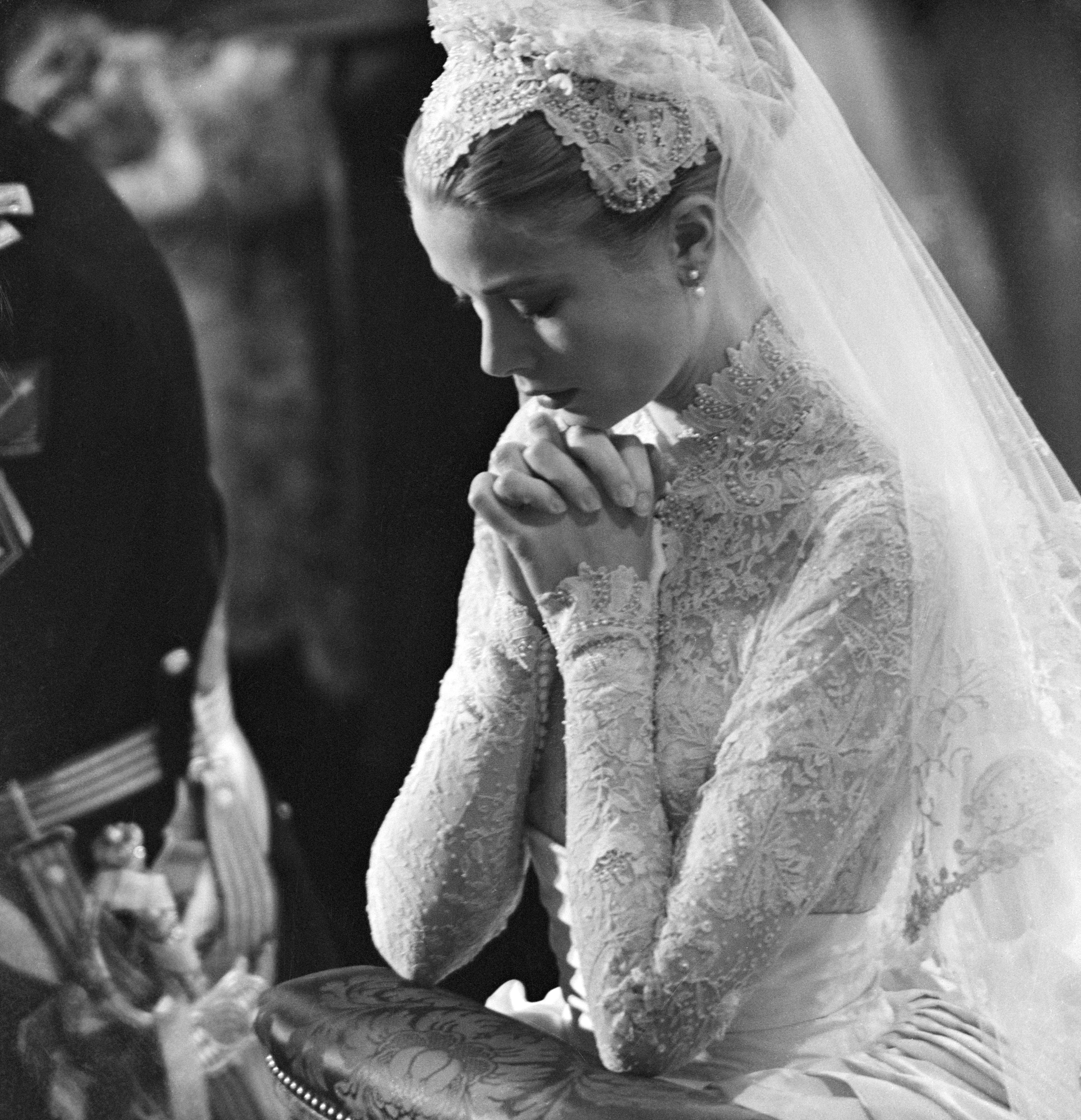 Grace Kelly reza durante su boda con el Príncipe Rainie III el 19 de abril de 1956, en Mónaco. | Fuente: Getty Images