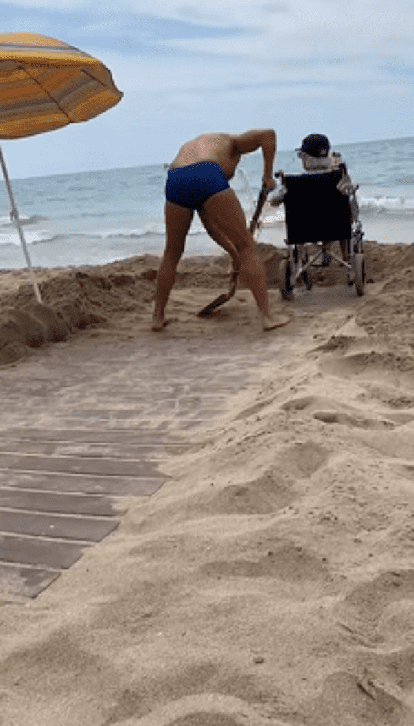 Hombre despeja rampa llena de arena para llevar a su madre en silla de ruedas hasta la playa. | Foto: Facebook/Manuel Lara Rosa.