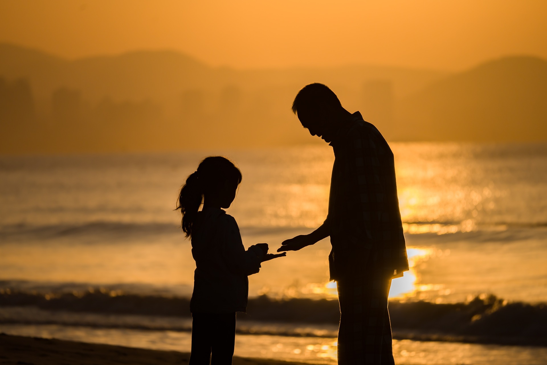 Un padre con su hija en la playa | Fuente: Pixabay