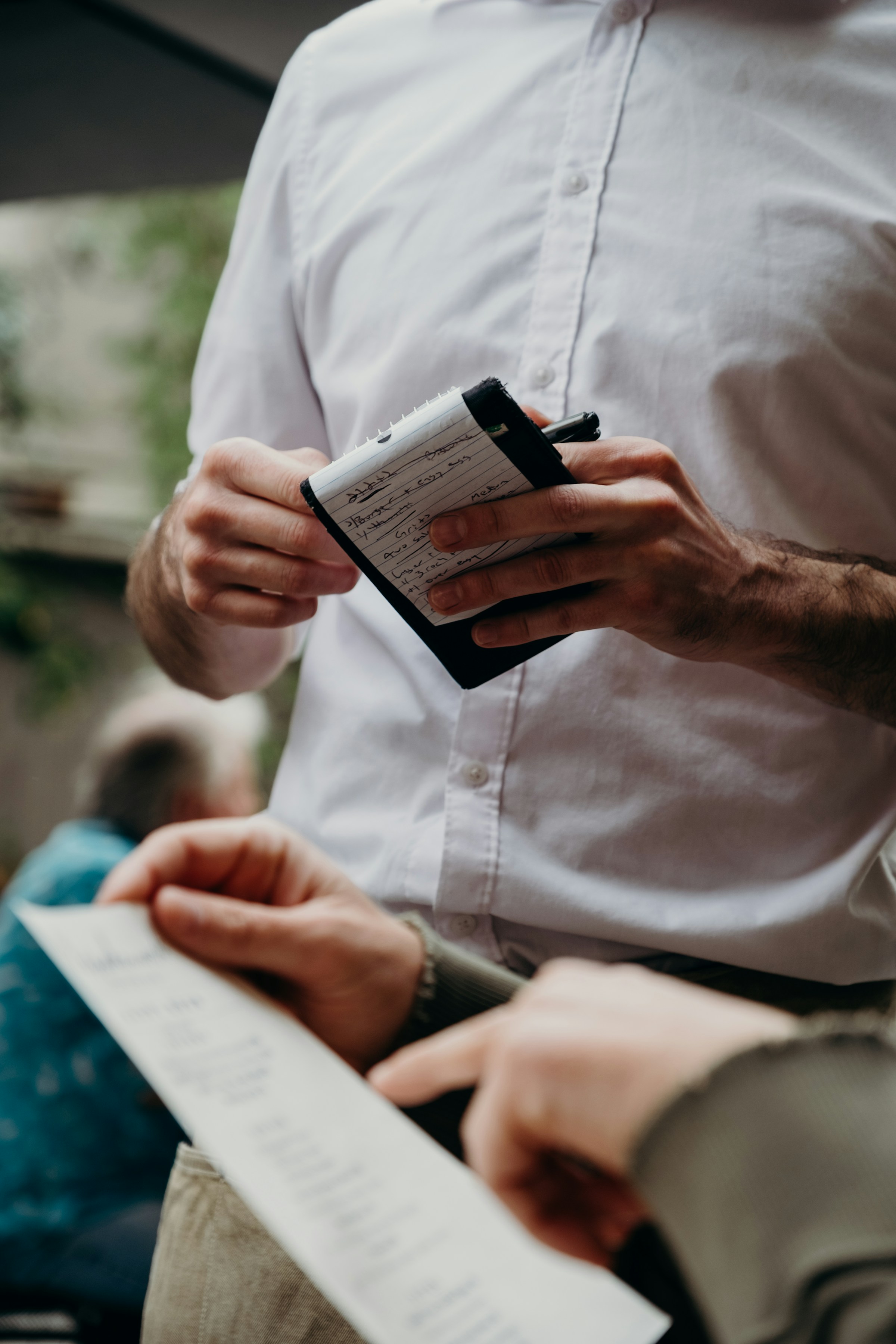 Un camarero en un restaurante junto a un cliente revisando la cuenta | Fuente: Unsplash