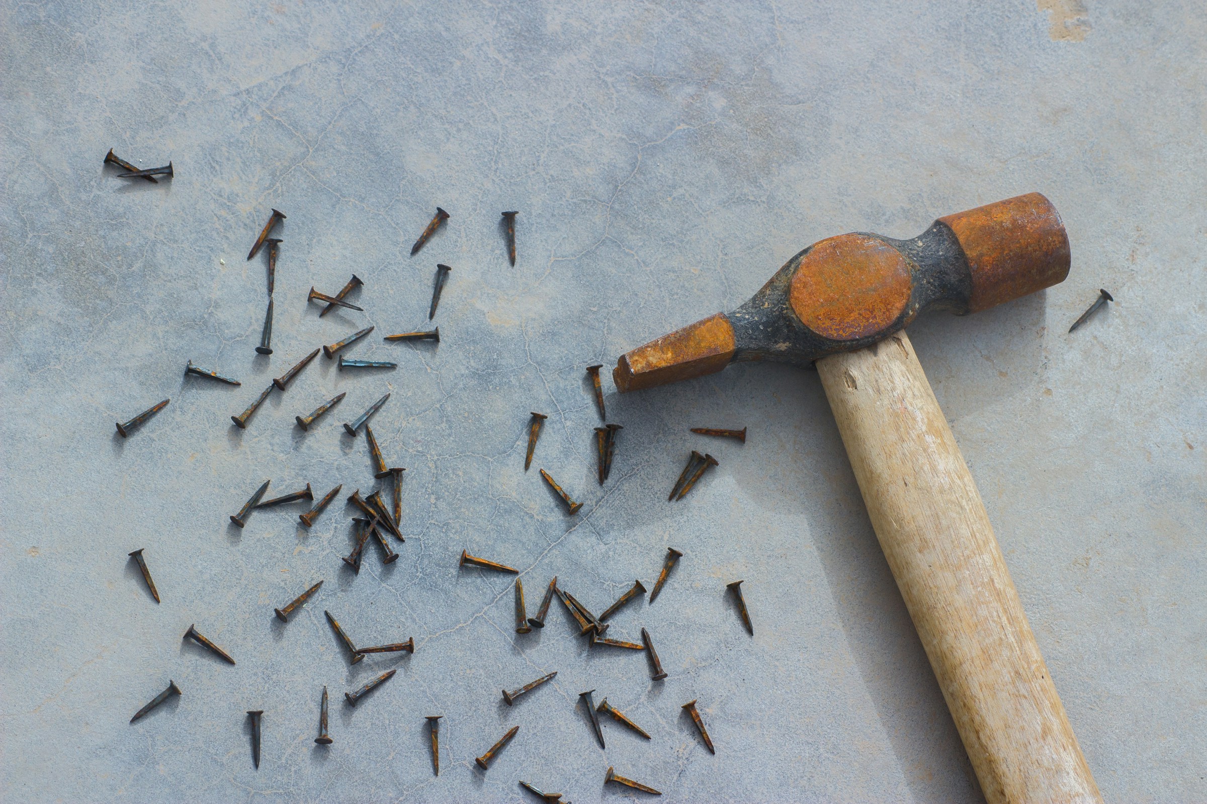 Clavos esparcidos cerca de un martillo | Fuente: Unsplash