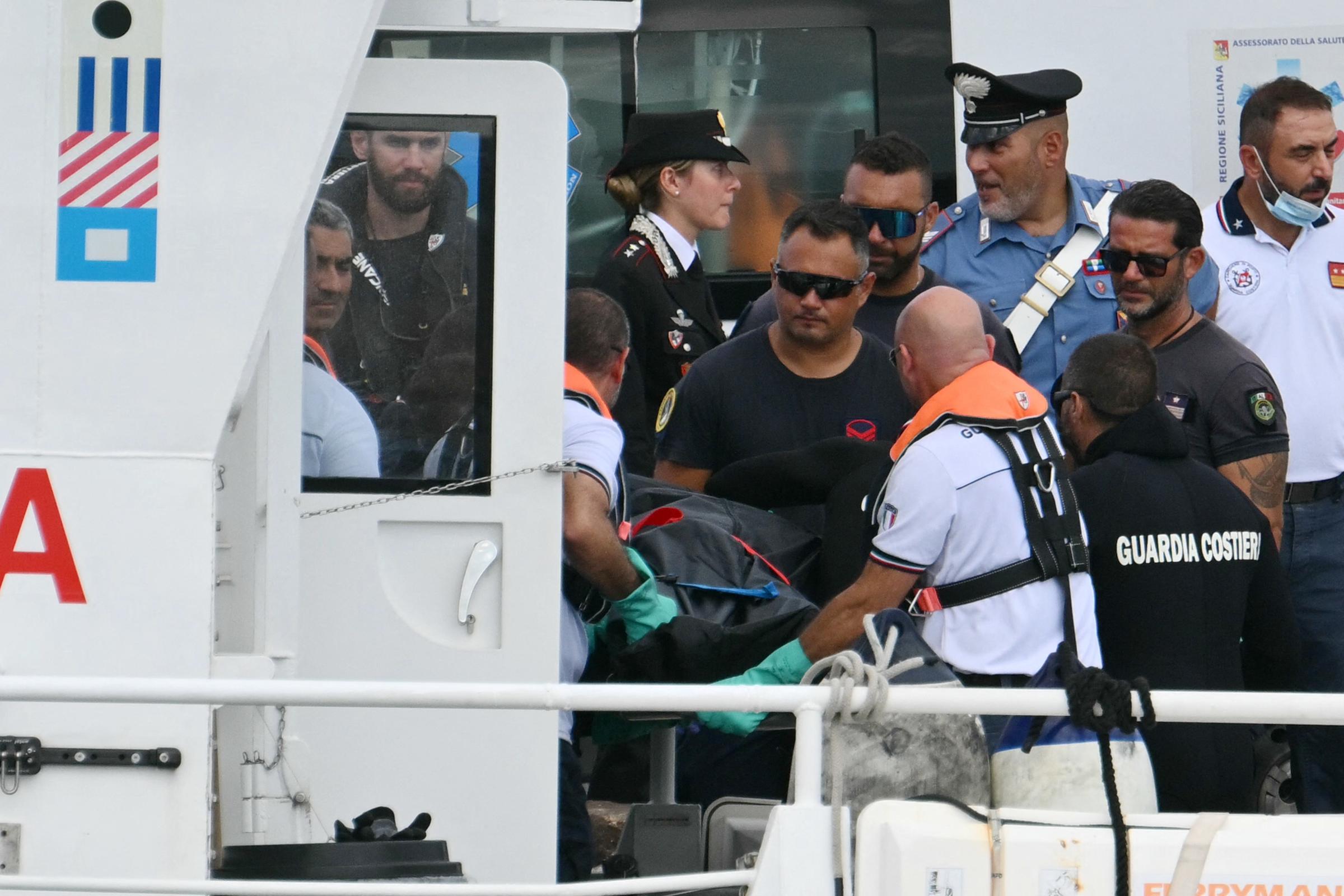 Guardacostas italianos (Guardia Costiera) transportan un cadáver en Porticello, cerca de Palermo, el 21 de agosto de 2024, dos días después de que se hundiera el yate de lujo Bayesian, de bandera británica. | Fuente: Getty Images