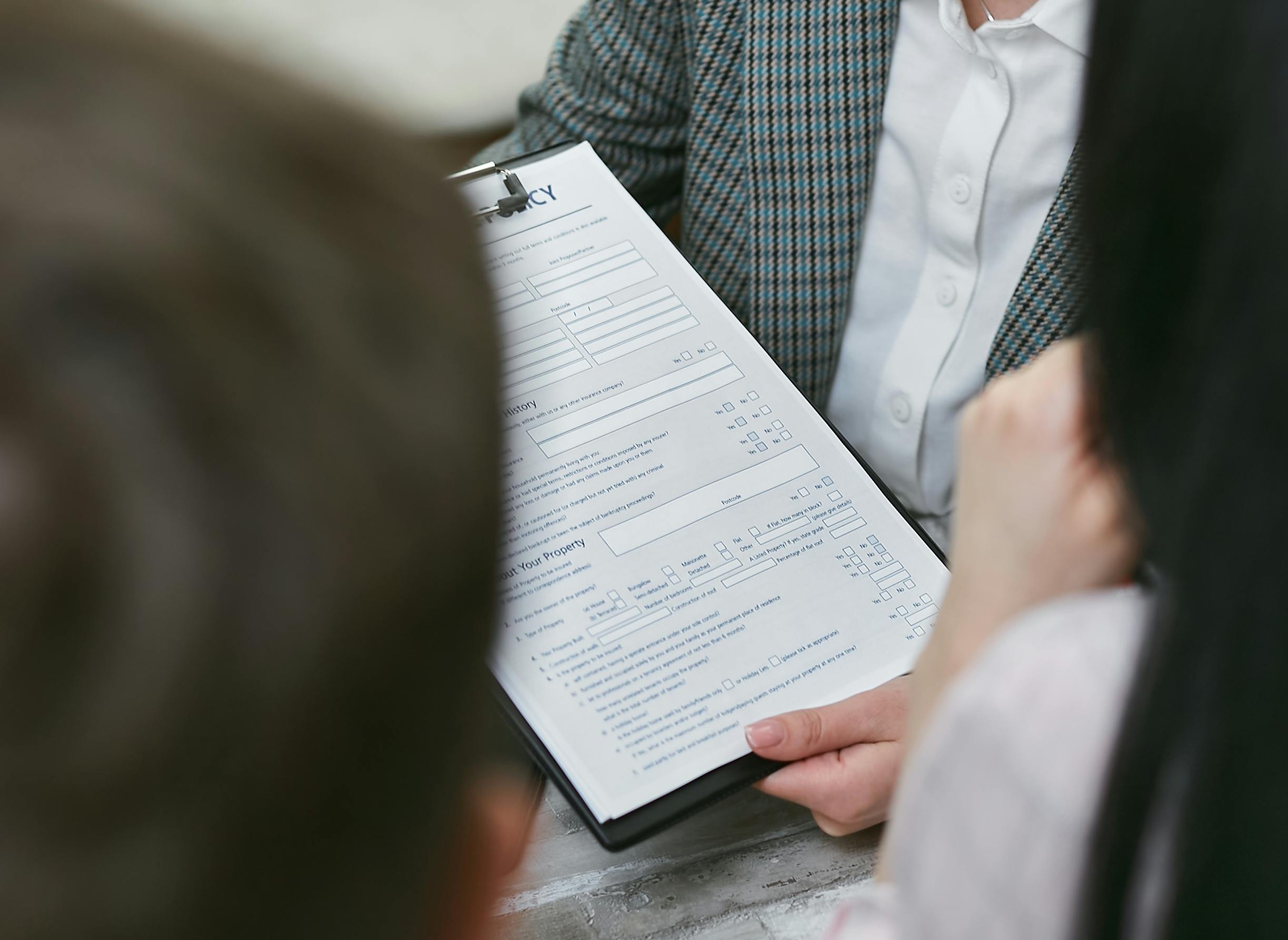 Una persona sostiene un portapapeles con un contrato | Fuente: Pexels