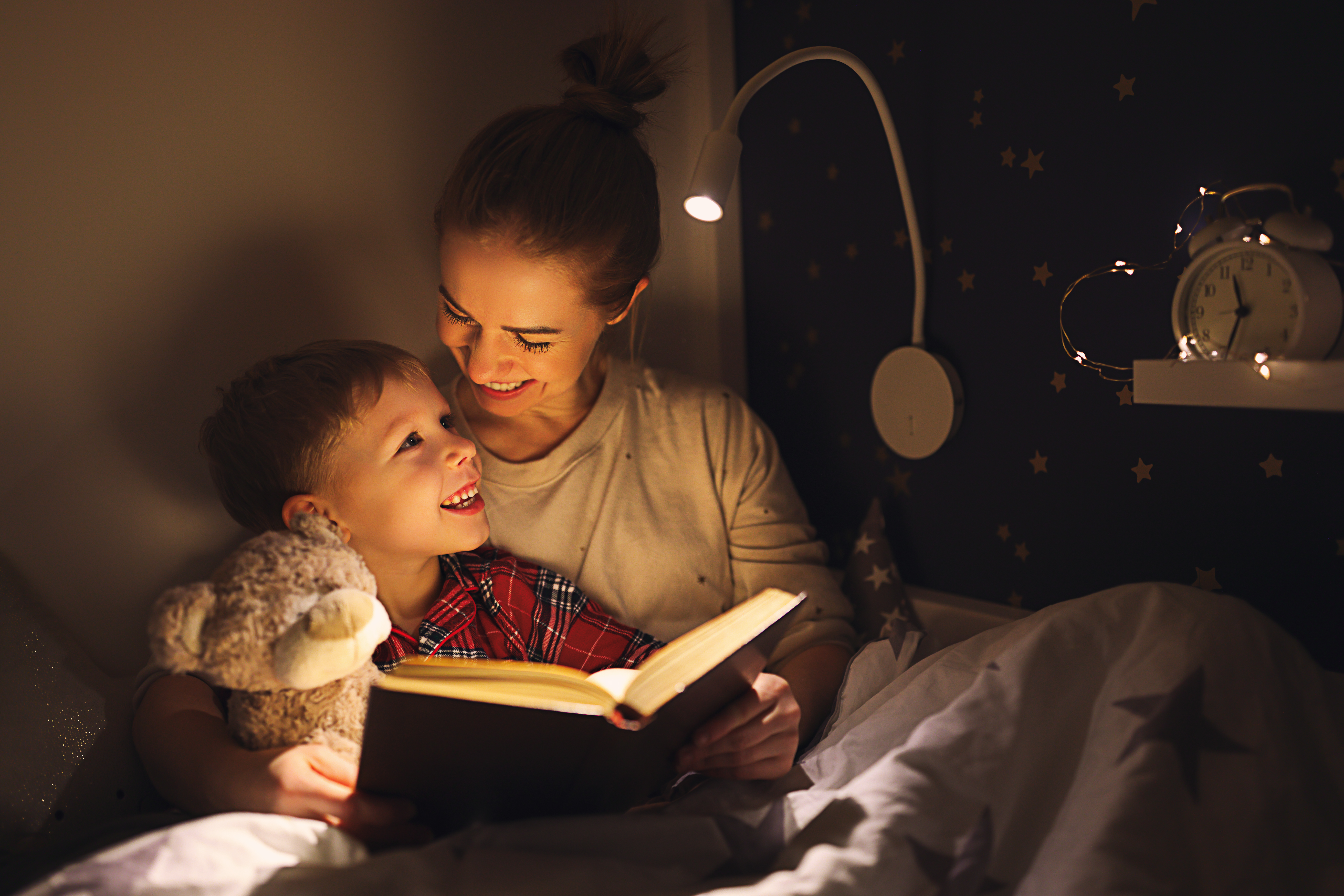 Madre e hijo abrazados y leyendo un libro | Foto: Getty Images