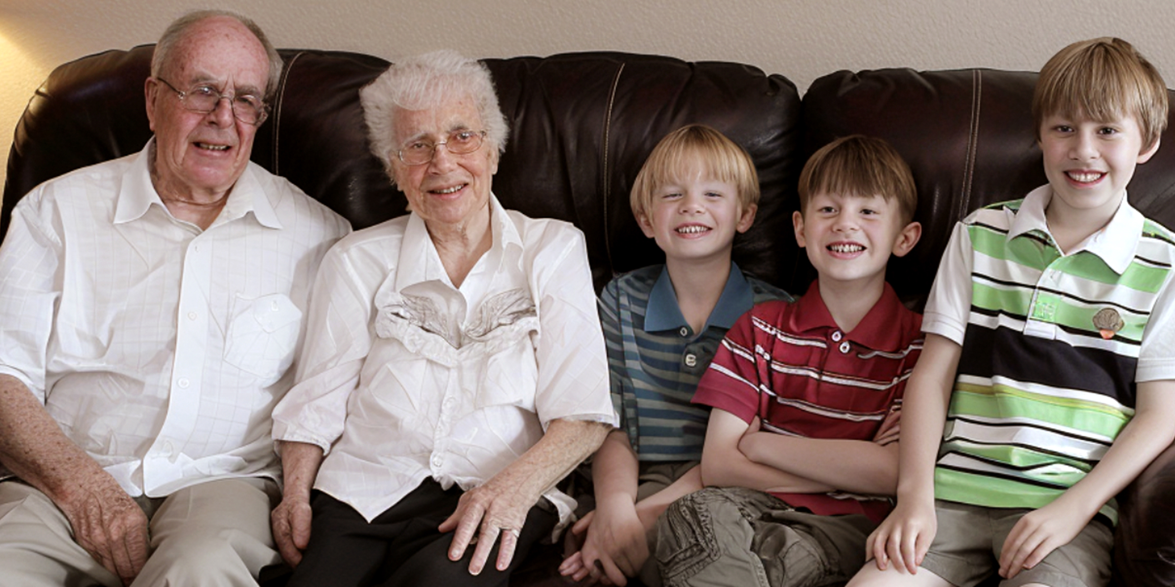 Abuelos y nietos sentados en un sofá | Fuente: AmoMama