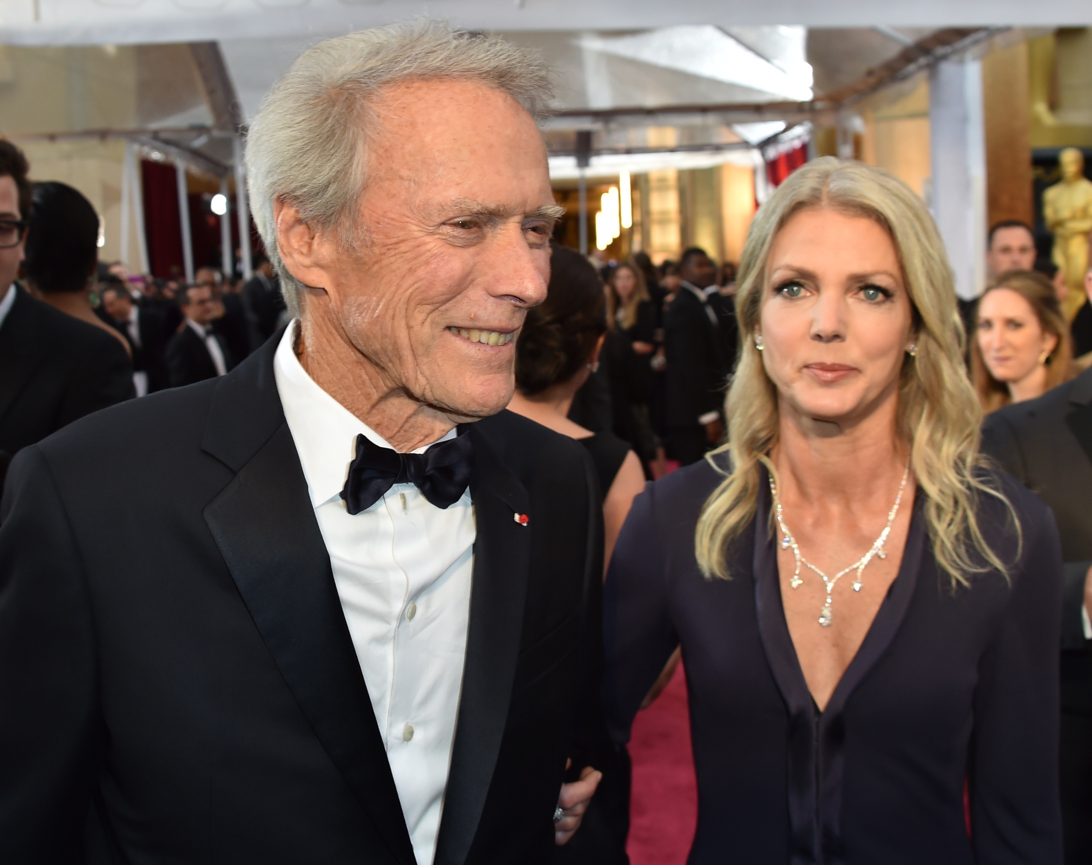 Clint Eastwood y Christina Sandera llegan a la alfombra roja de la 87ª edición de los Oscar en Hollywood, California, el 22 de febrero de 2015. | Fuente: Getty Images