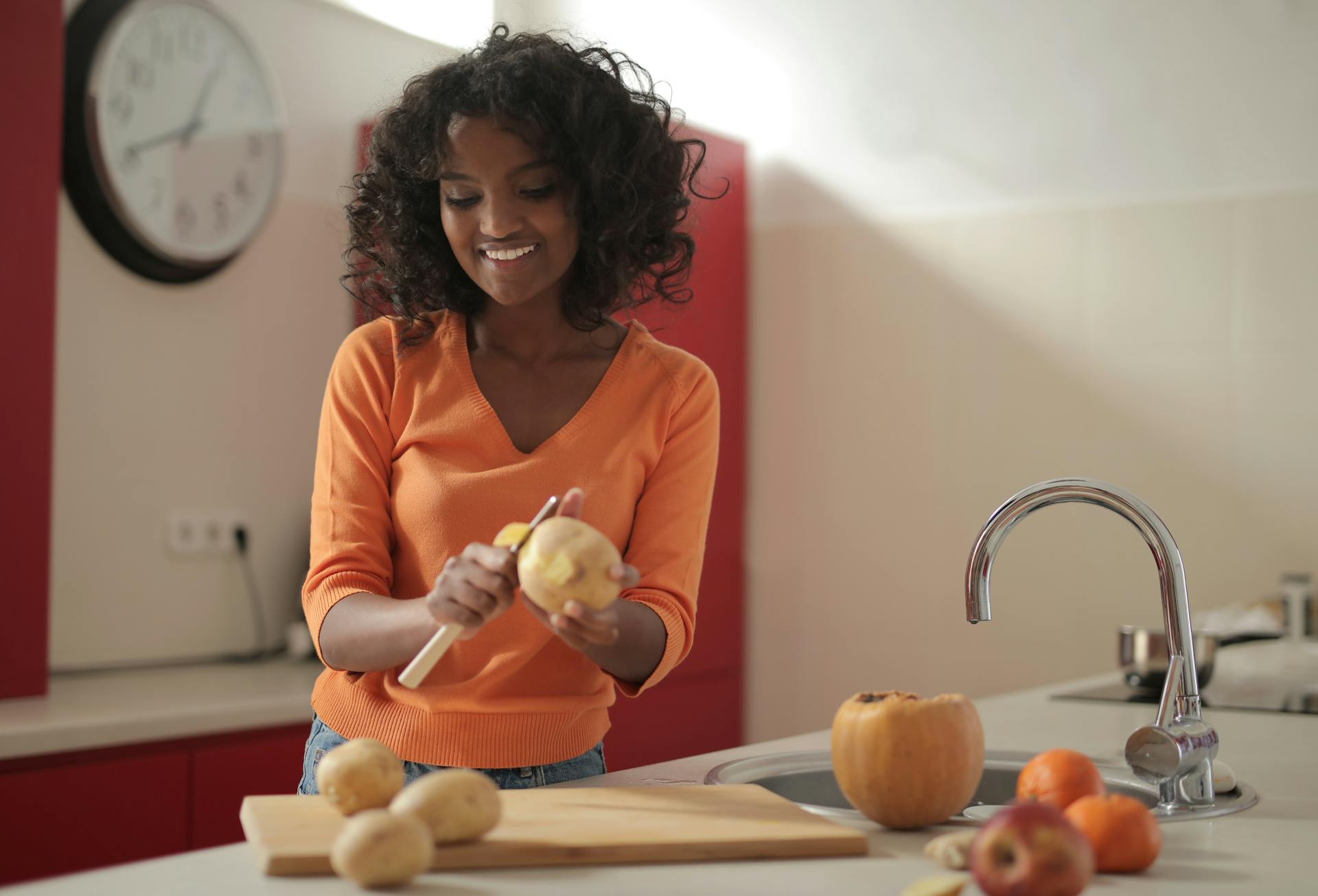 Una mujer pelando patatas | Fuente: Pexels