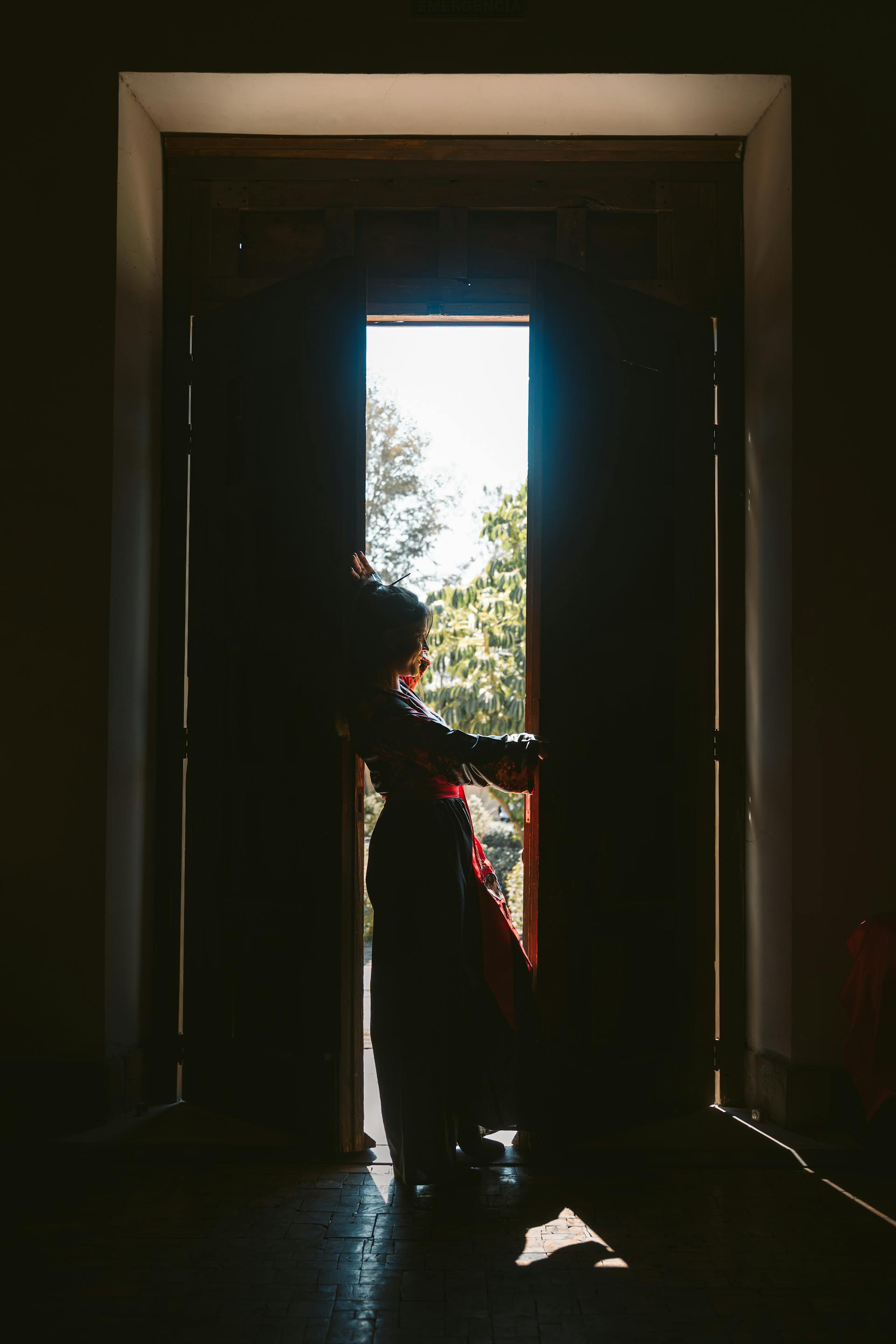 Una mujer silueteada en una puerta | Fuente: Pexels