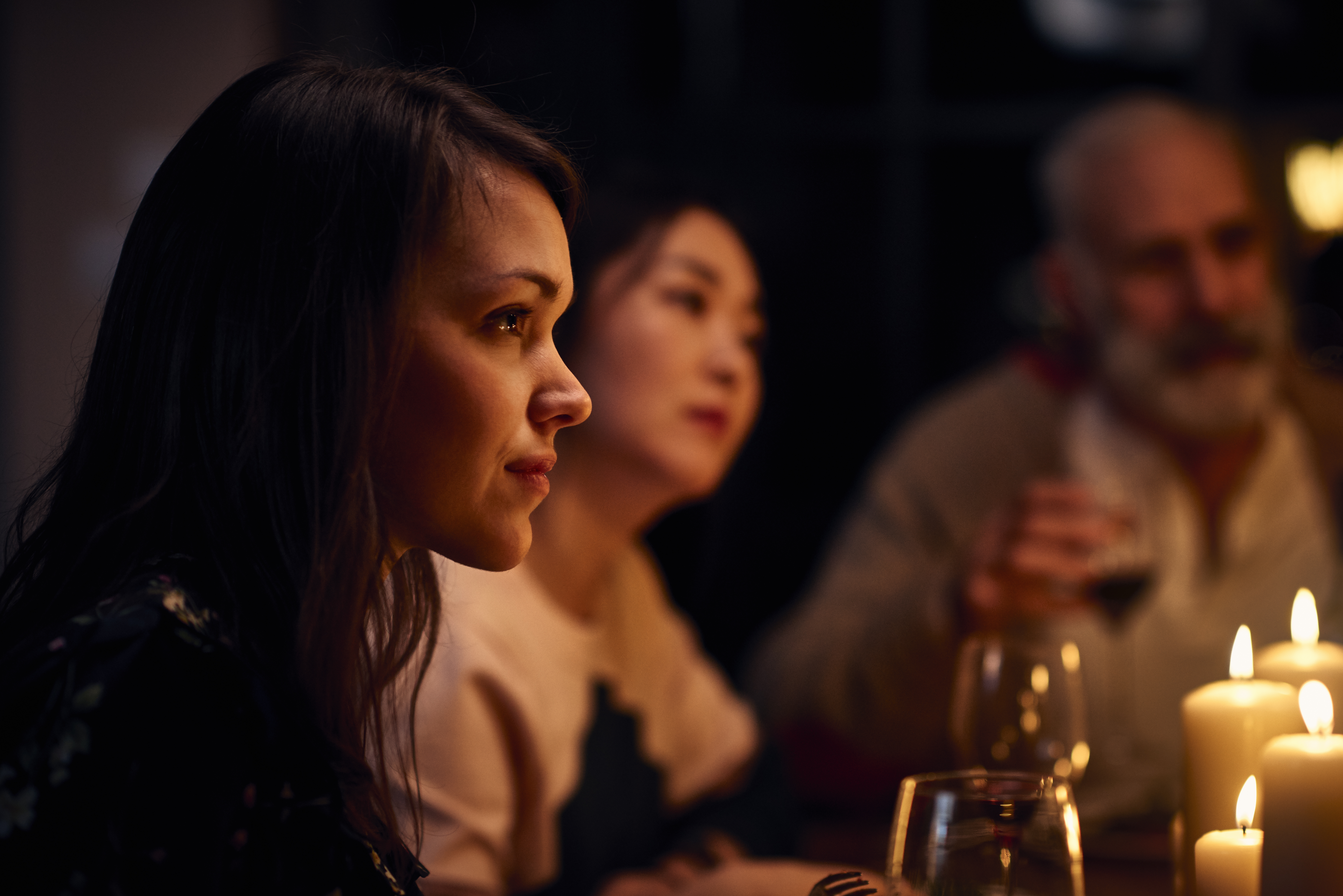 Mujer de aspecto sereno en una cena escuchando atentamente | Foto: Getty Images