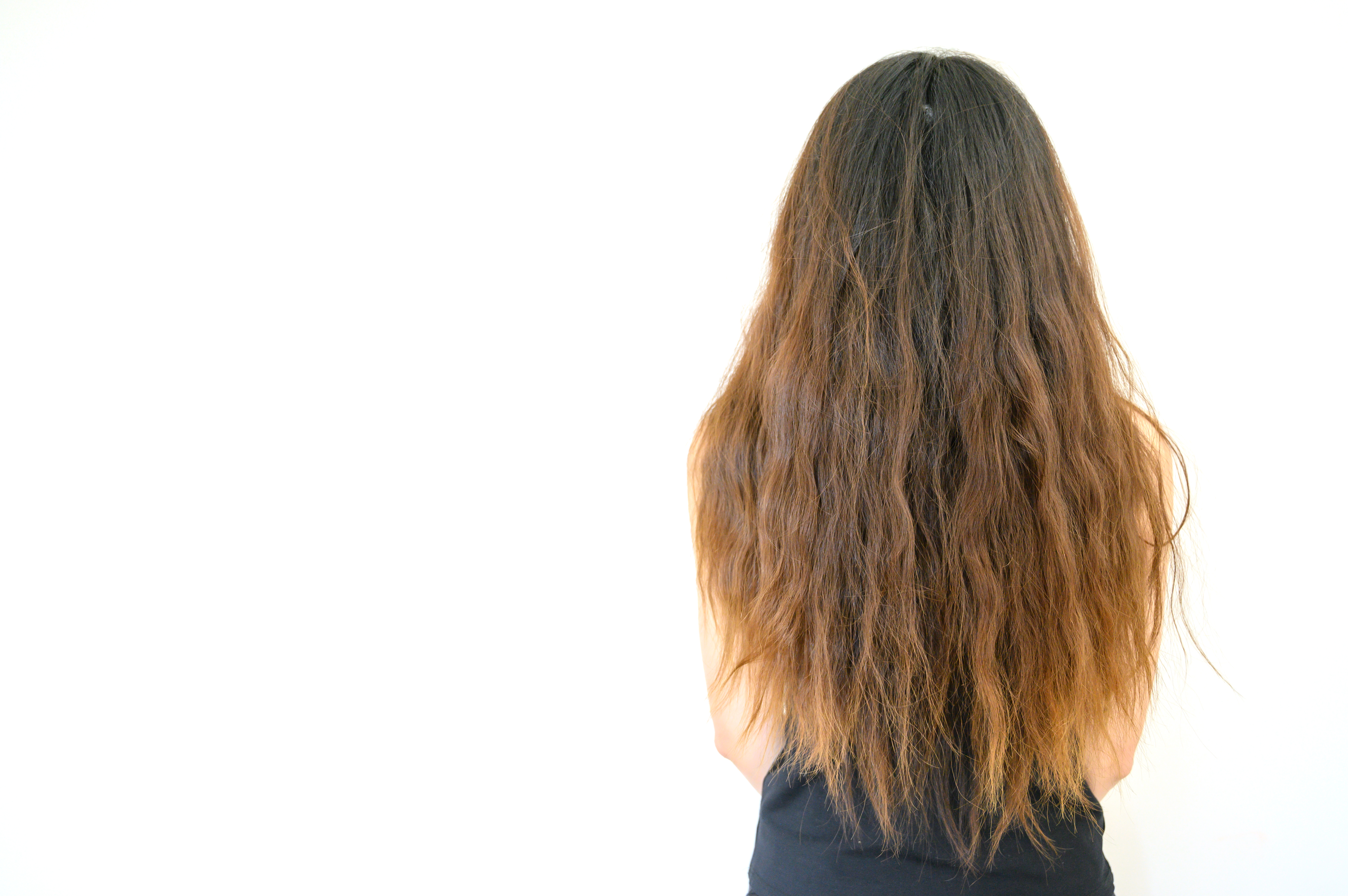 Vista trasera de una mujer joven con el pelo encrespado | Foto: Shutterstock