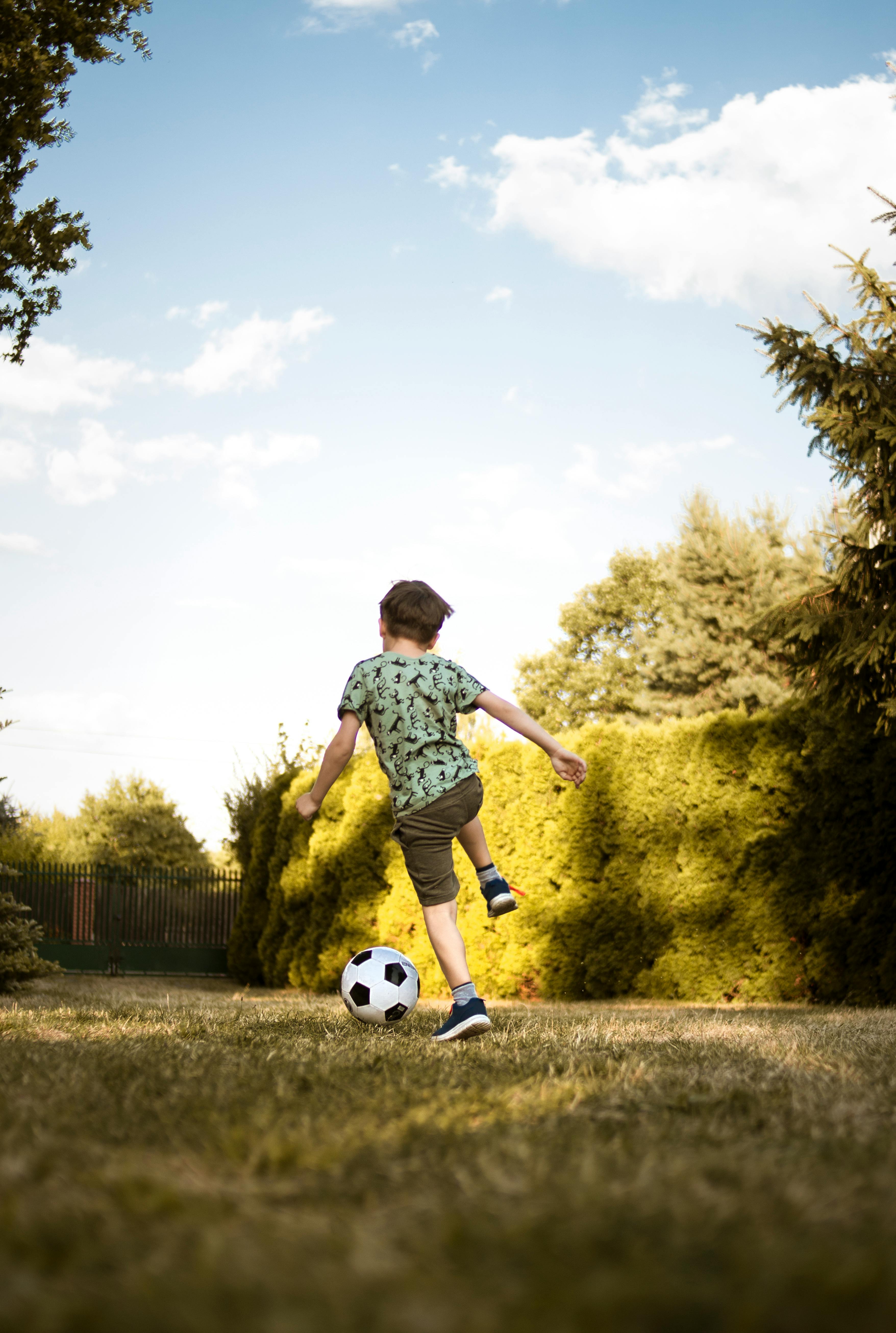 Un niño jugando con un balón de fútbol | Fuente: Pexels