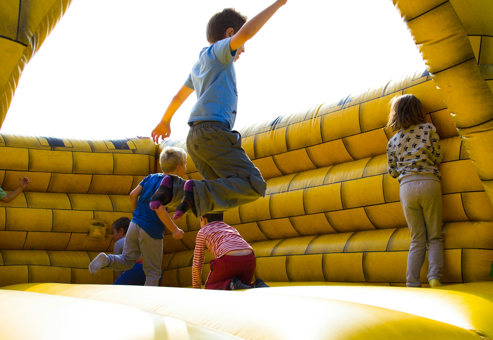 Niños jugando en un castillo hinchable | Fuente: Pexels