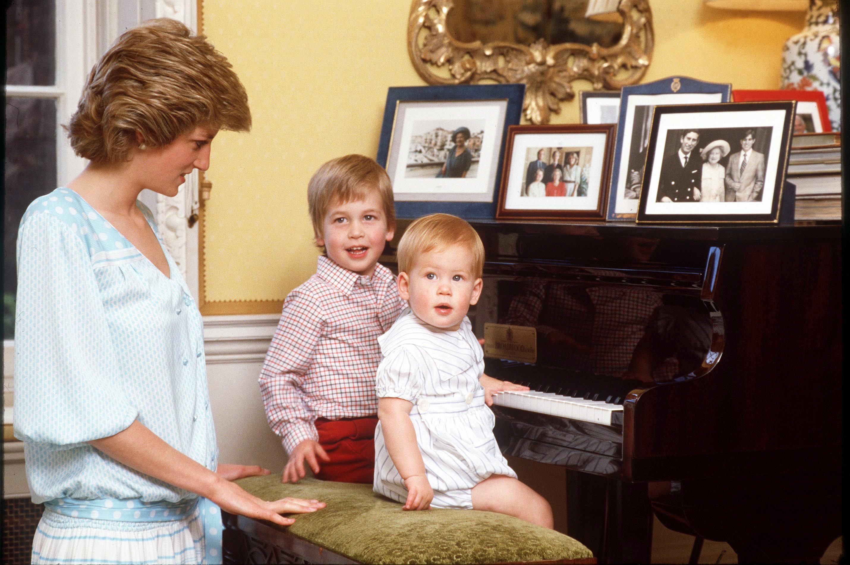 La princesa Diana con el príncipe William y el príncipe Harry al piano en casa en el Palacio de Kensington en 1985 | Foto: Getty Images