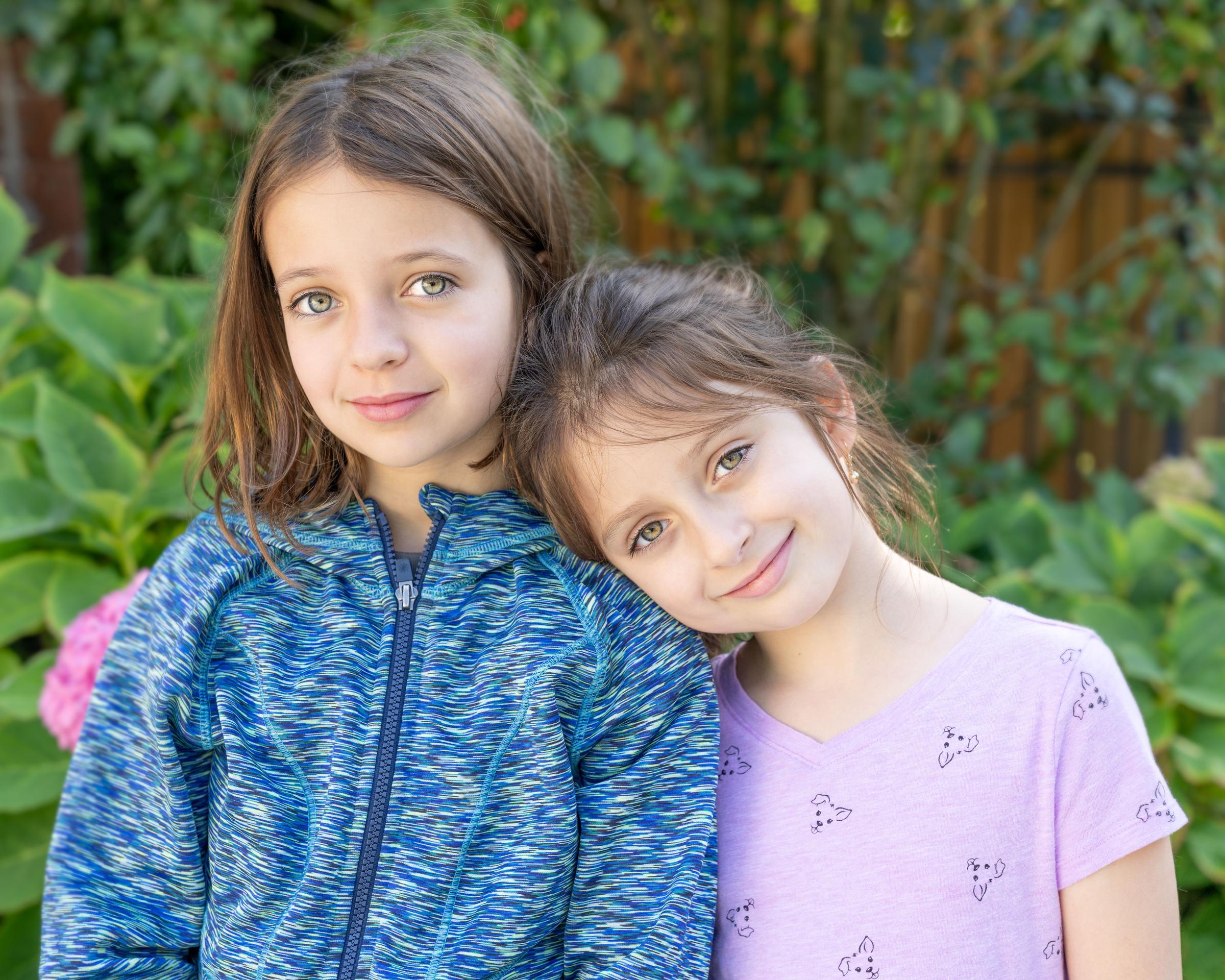 Dos niñas sonríen al aire libre, mostrando amistad y alegría | Fuente: Pexels