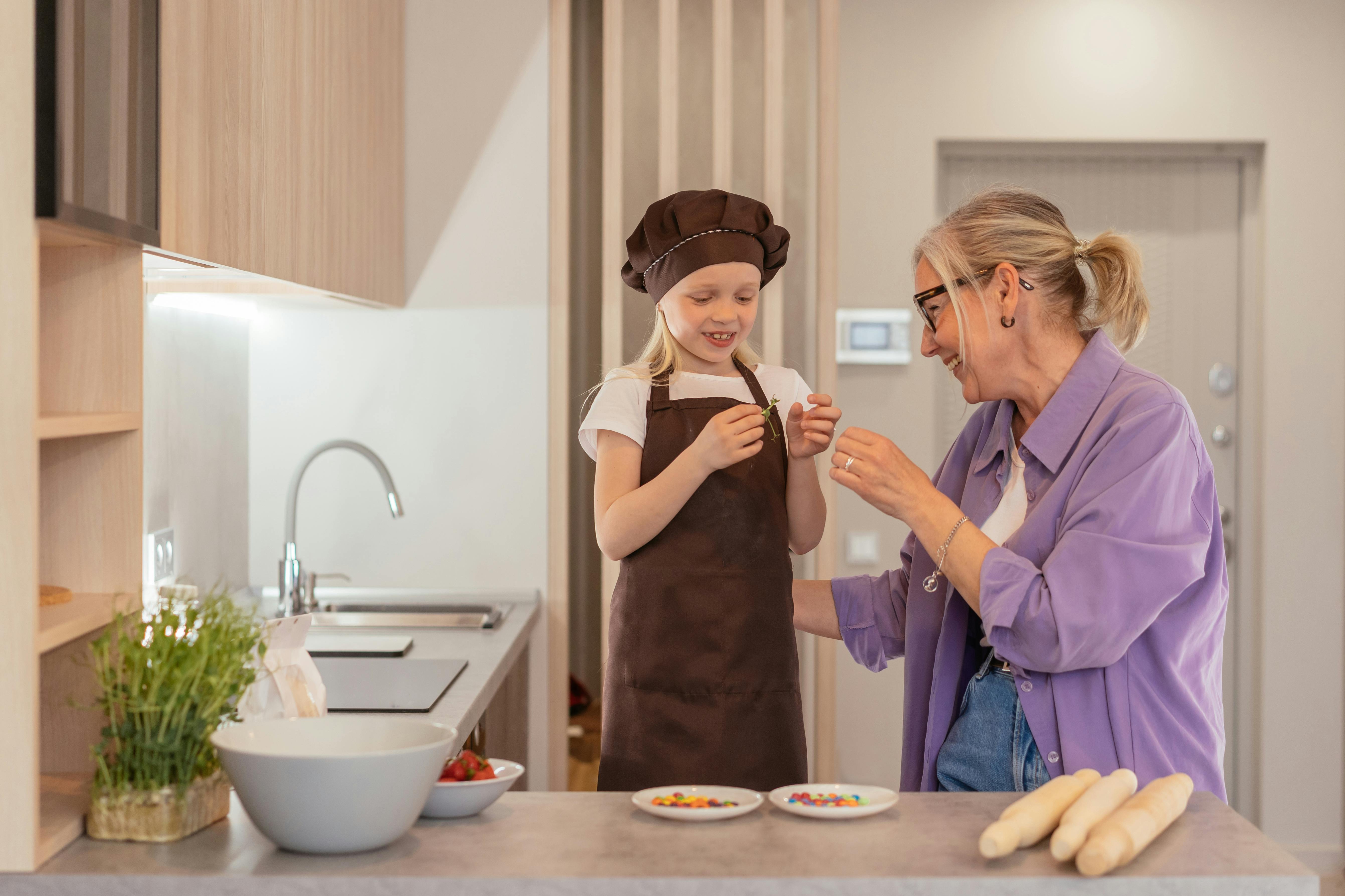 Una mujer feliz en la cocina con su nieto | Fuente: Pexels