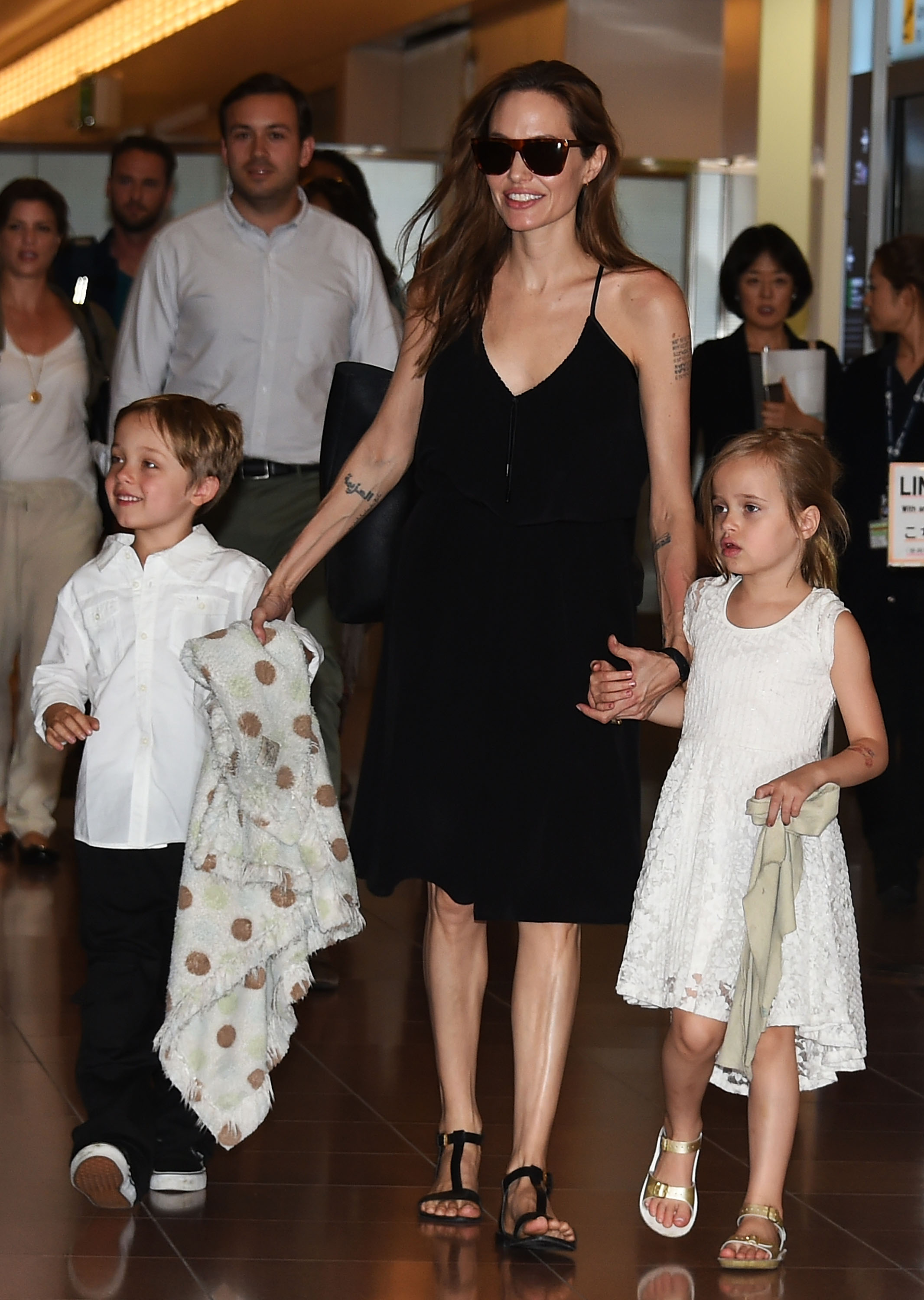 Knox Jolie-Pitt con su madre y su hermana gemela en el aeropuerto de Haneda el 21 de junio de 2014 en Tokio, Japón. | Fuente: Getty Images