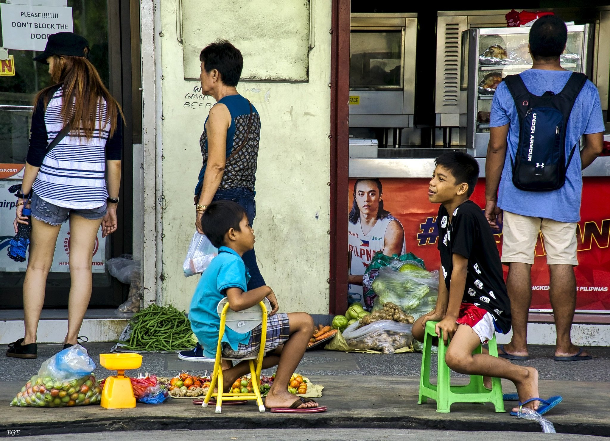Niños conversando mientras muestran vegetales en una acera. | Imagen: Flickr