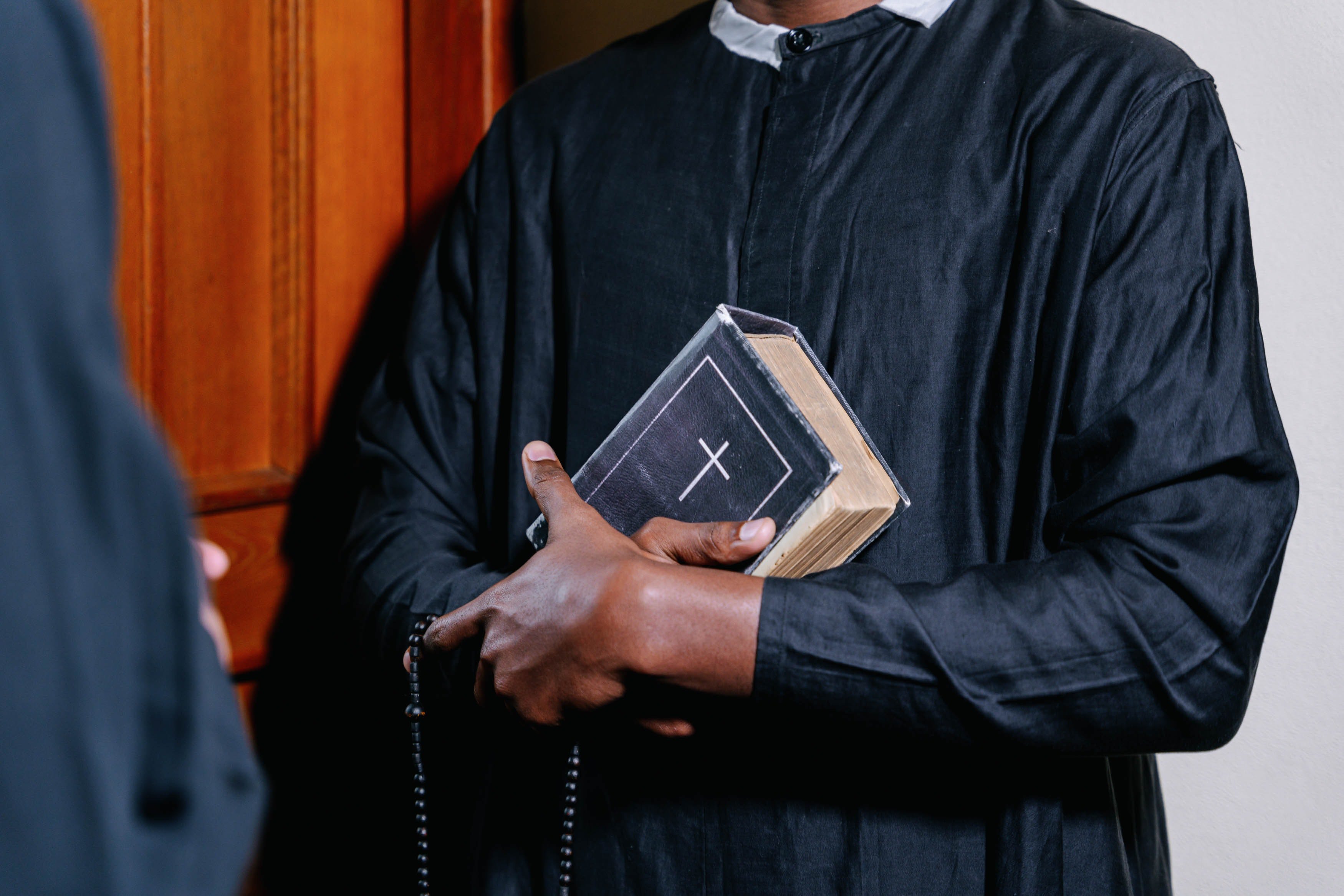 Religioso abrazando una biblia. | Foto: Pexels