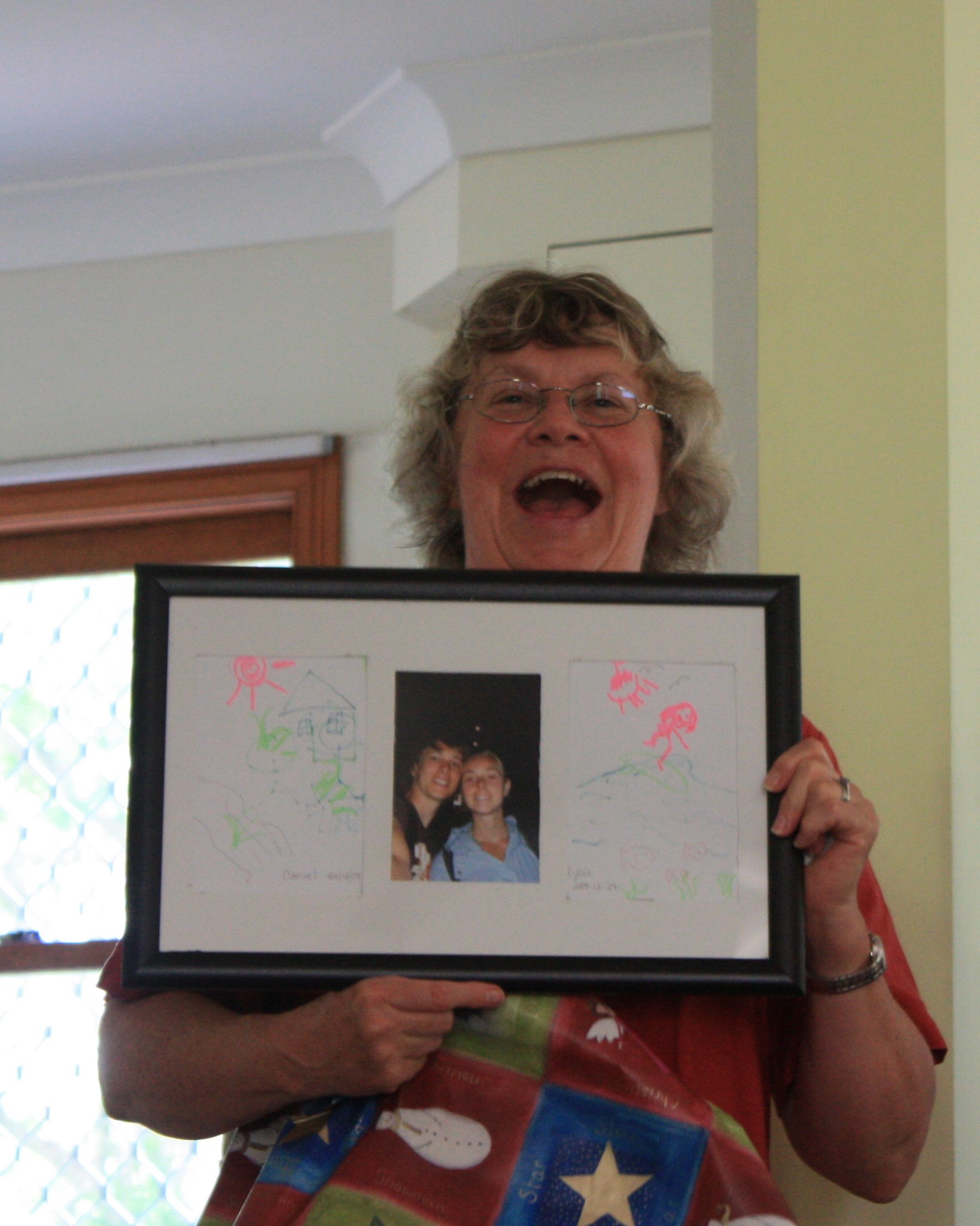 Mujer mayor sonriente con un marco de fotos | Foto: Flickr.com/Daniel Pink (CC BY 2.0)
