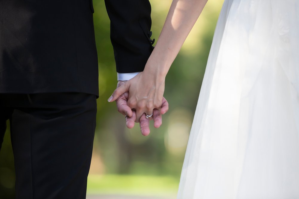 Pareja sosteniendo sus manos durante su boda. | Foto: Shutterstock