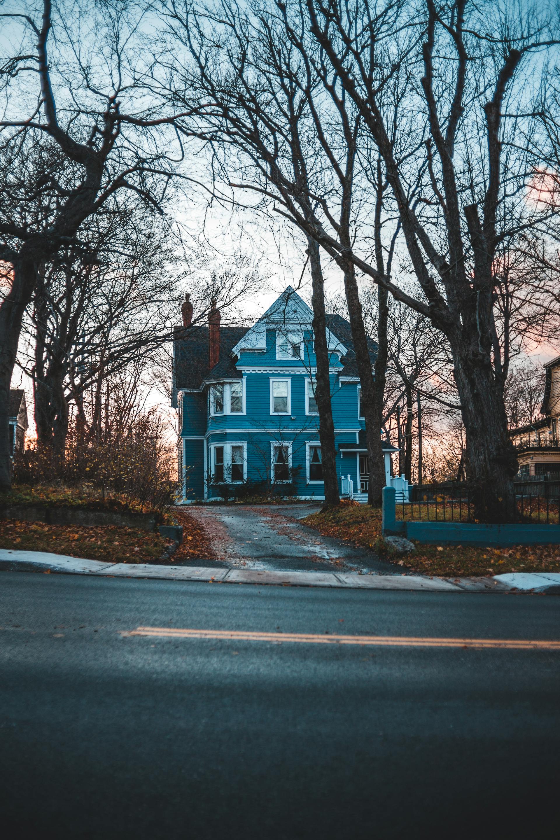 Una casa azul cerca de la carretera | Fuente: Pexels