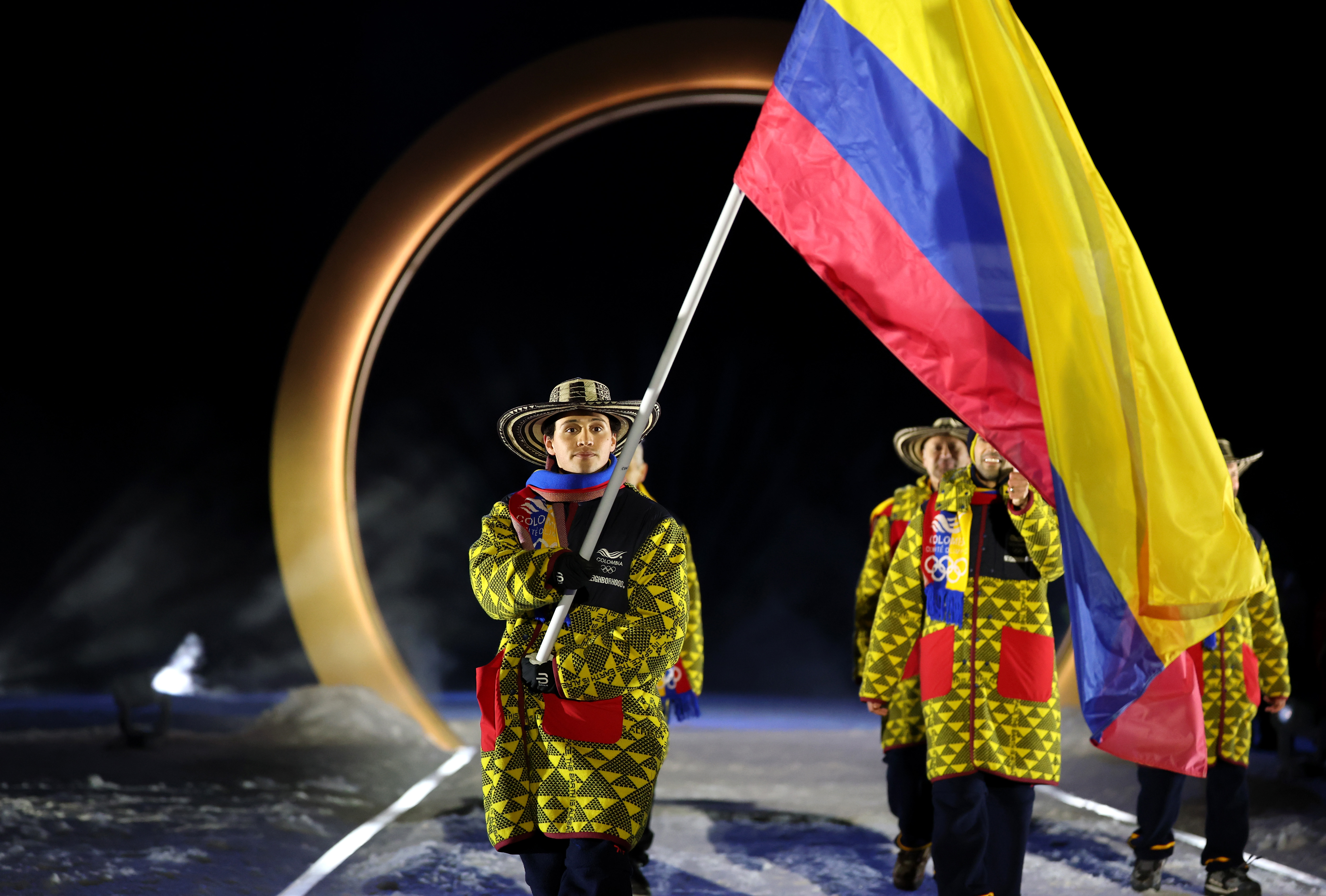 El abanderado Fredrik Fodstad, de Colombia, ingresa con el equipo al estadio durante la ceremonia inaugural de los Juegos Olímpicos de Invierno Milano Cortina 2026 en el Estadio de Salto de Esquí Predazzo el 6 de febrero de 2026 en Val di Fiemme, Italia. | Fuente: Getty Images