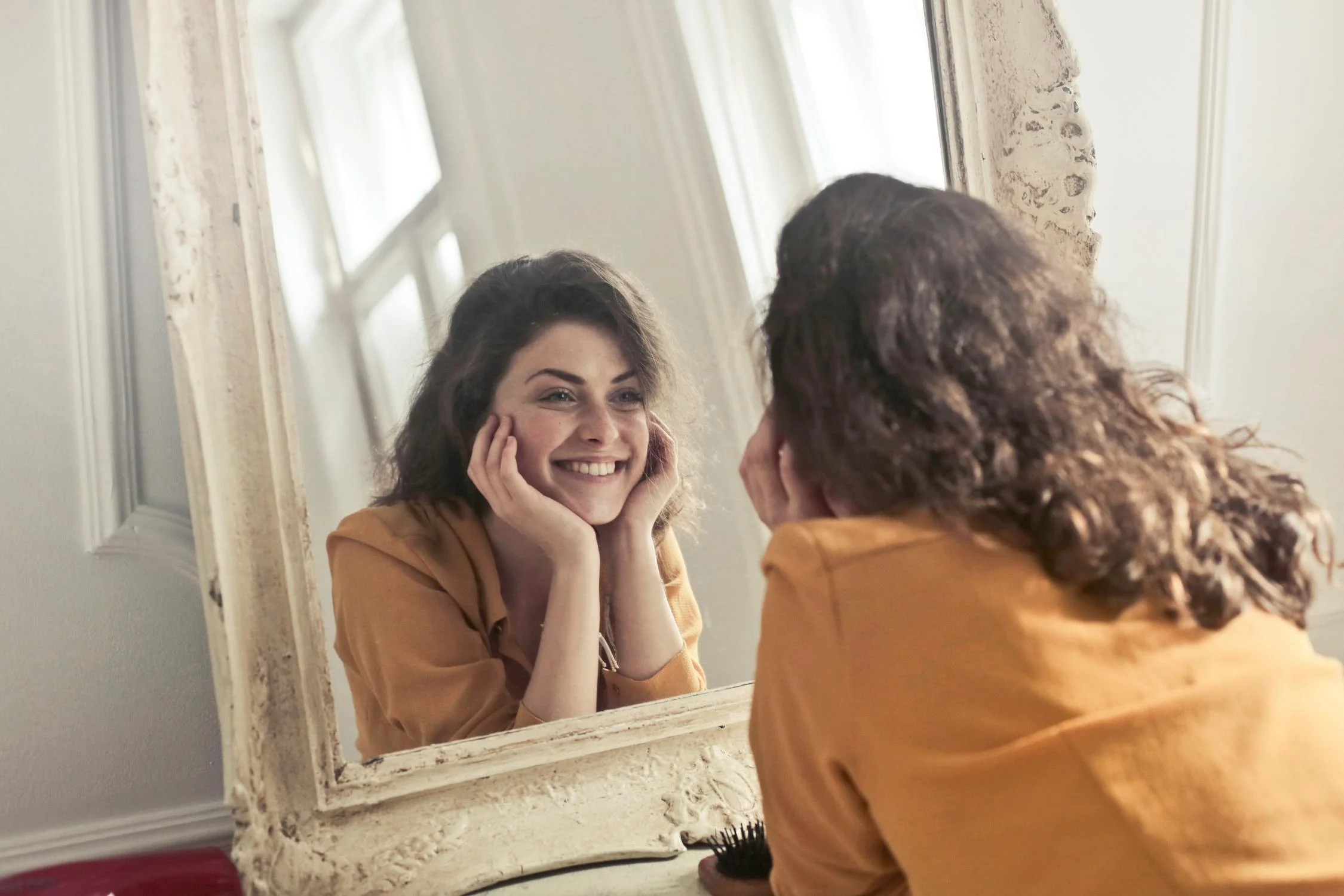 Una mujer sonriéndose a sí misma | Fuente: Pexels