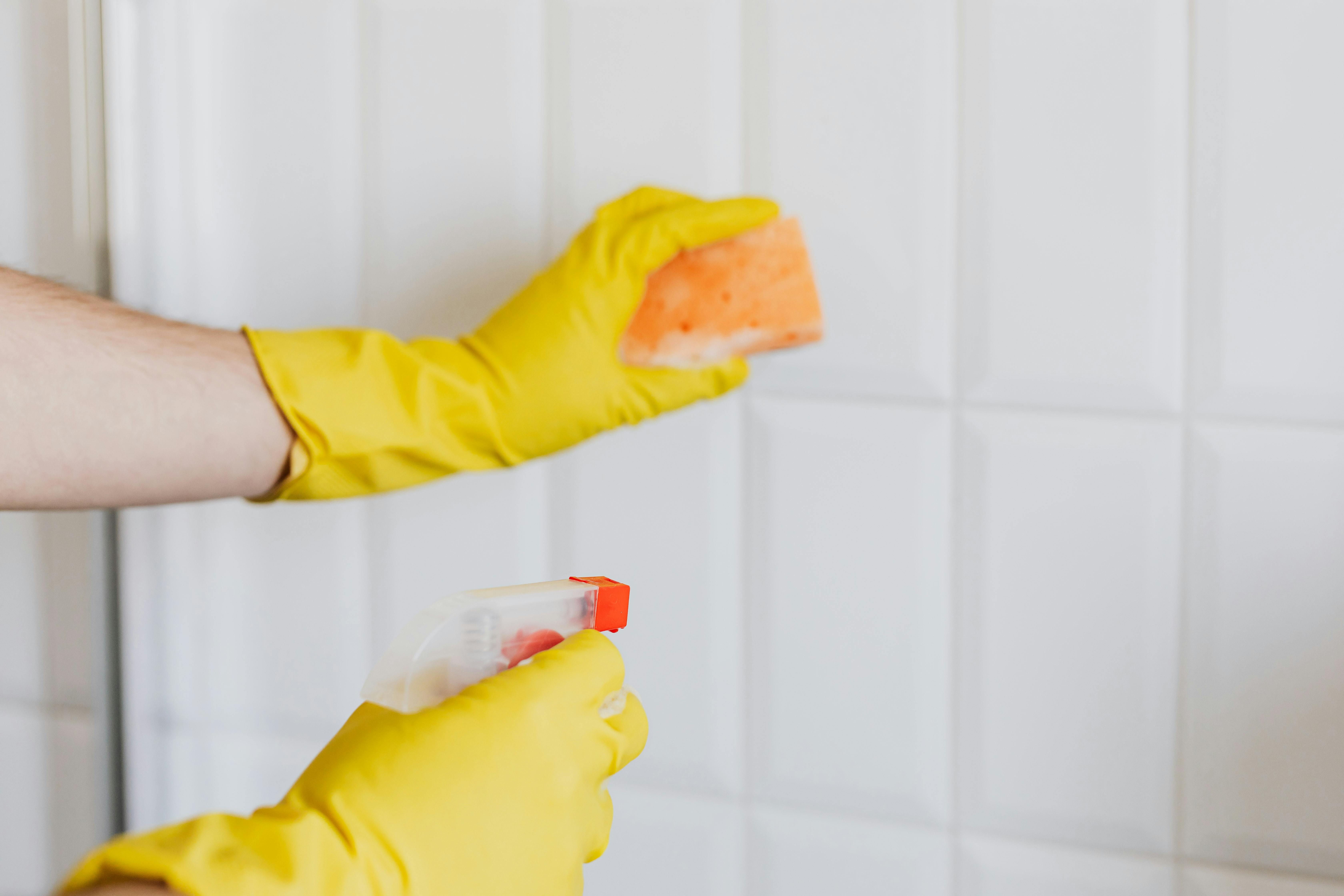 Una persona limpiando un baño con guantes amarillos | Fuente: Pexels