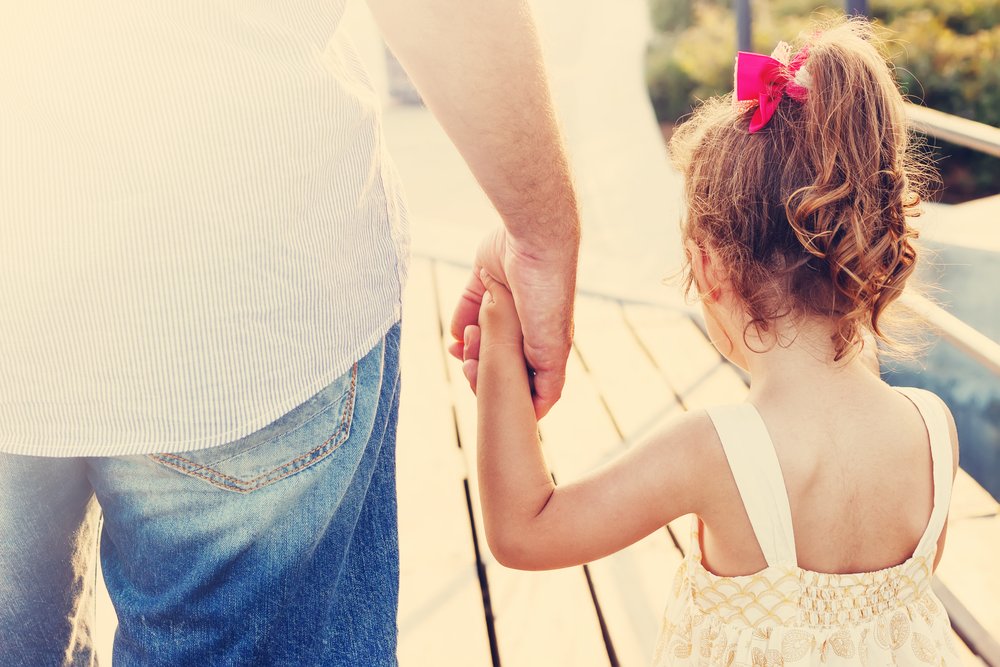 Niña y papá tomados de las manos. | Foto: Shutterstock