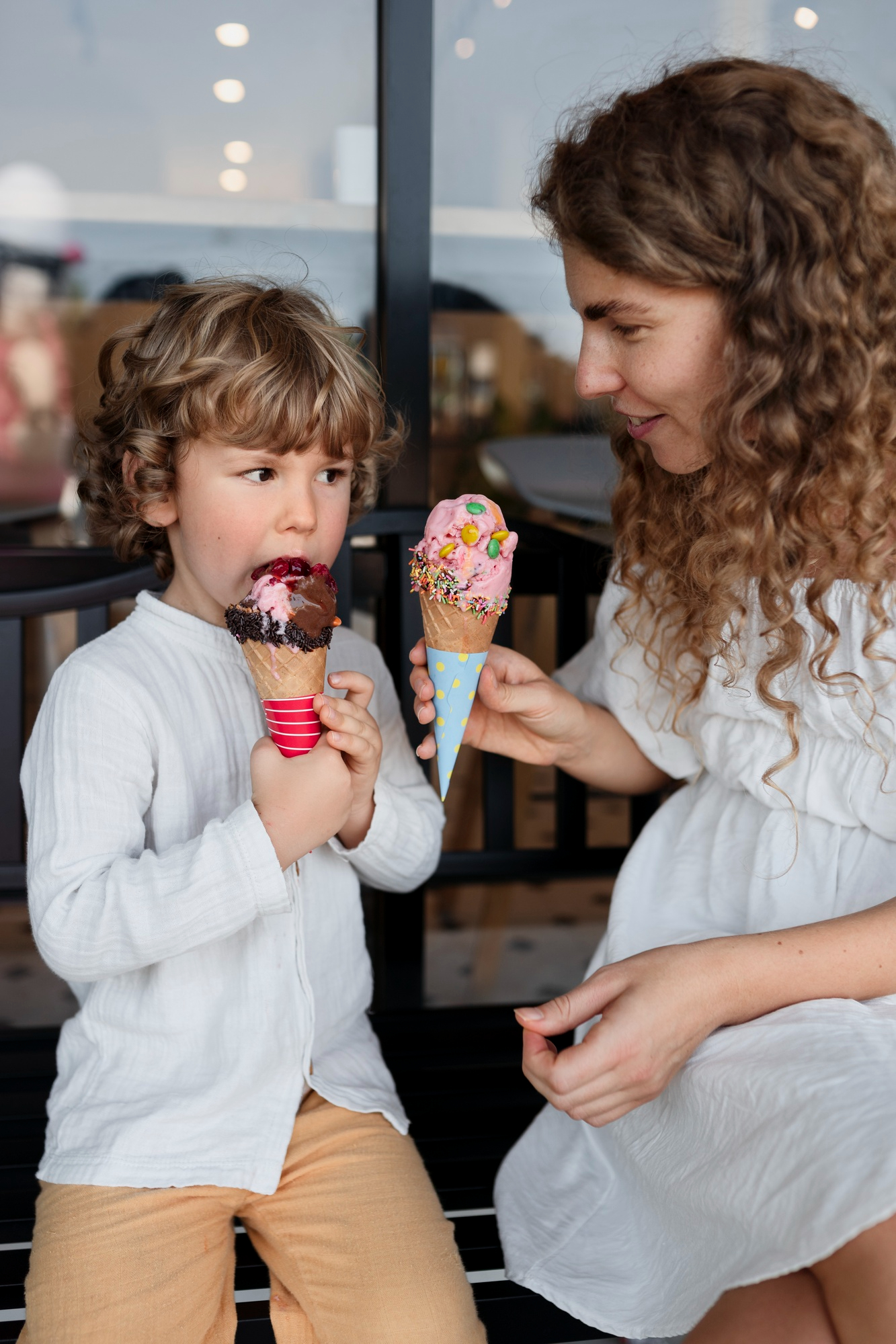 Una mujer dando cucuruchos de helado a un niño | Fuente: Freepik