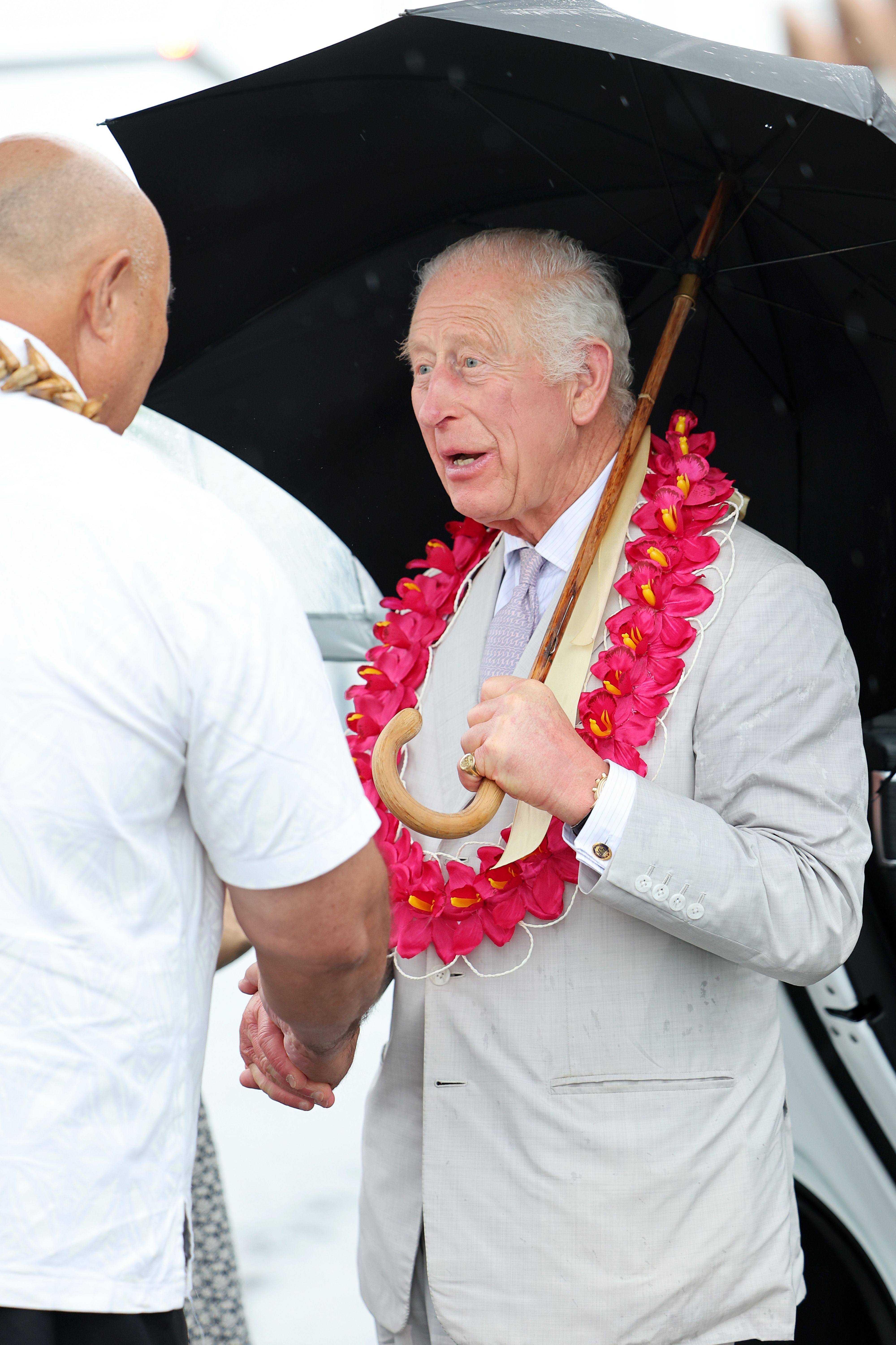 El rey Charles III interactuando con un samoano antes de embarcar en el avión de la Real Fuerza Aérea Australiana tras la despedida | Fuente: Getty Images