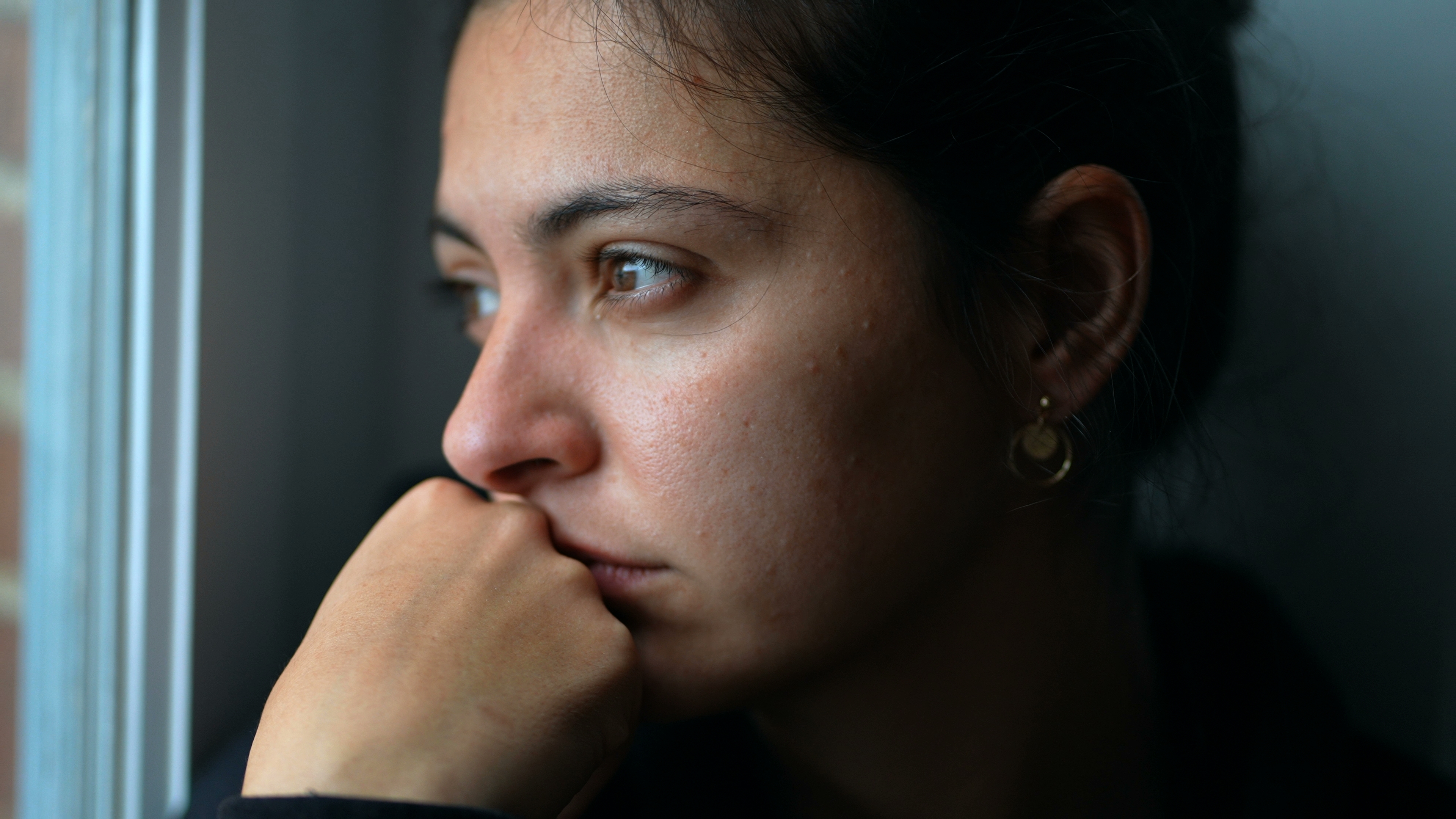 Joven pensativa mirando por la ventana | Foto: Shutterstock